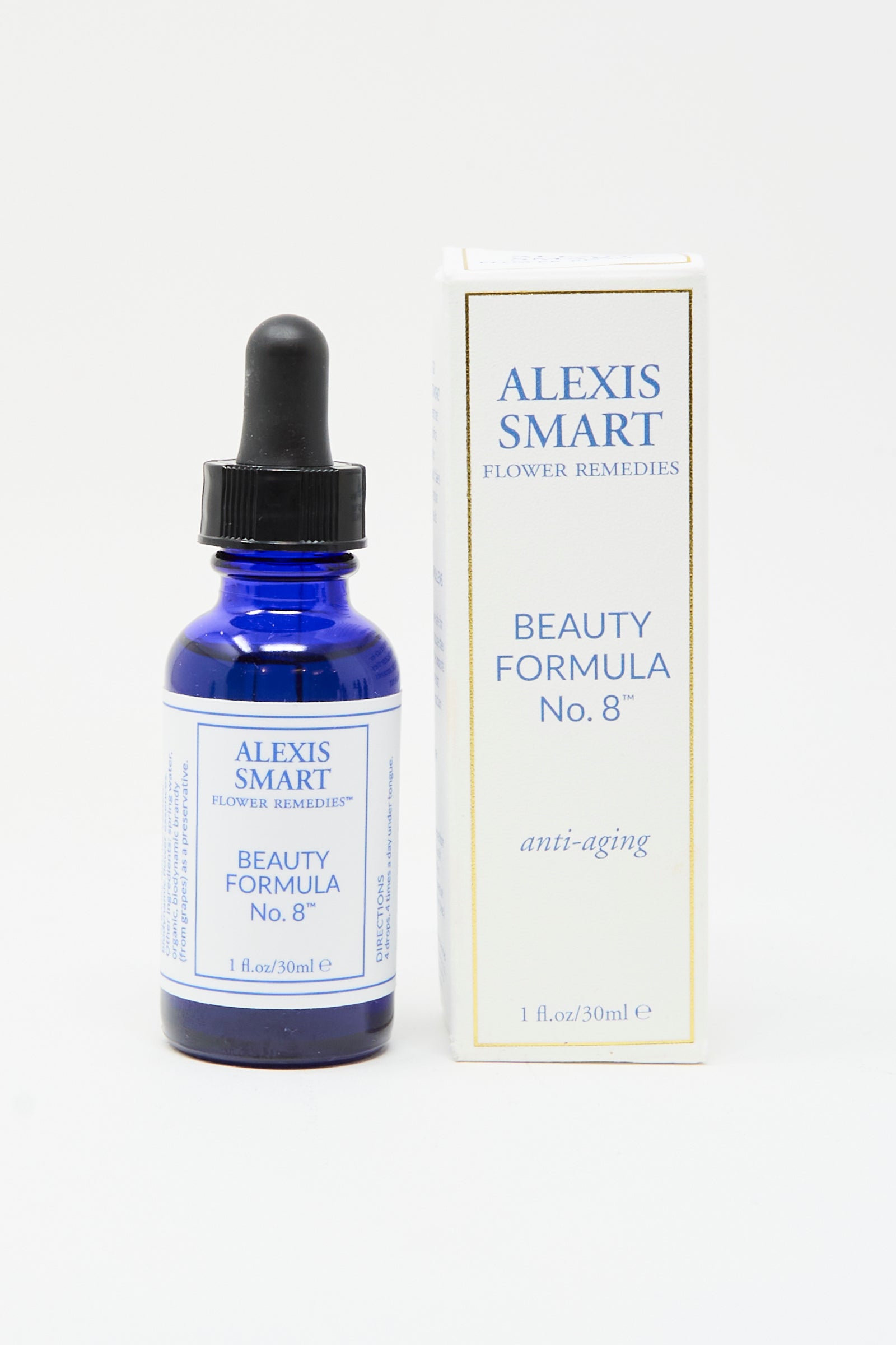 A blue Alexis Smart Flower Remedies - Beauty Formula No. 8 dropper bottle sits beside its white and gold "anti-aging" box, featuring organic flower essences for radiant skin.