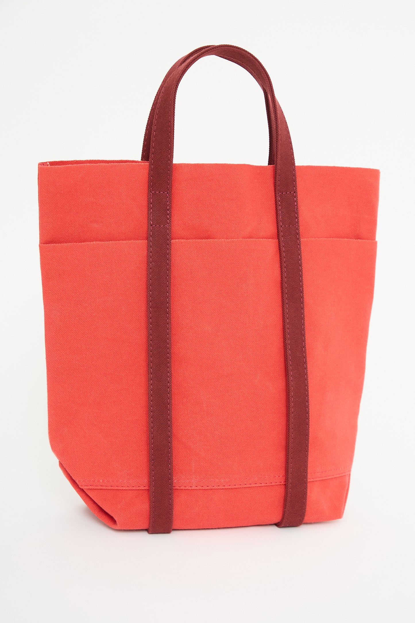 Amiacalva Light Ounce Canvas Tote in Scarlet and Burgundy with brown handles on a white background.