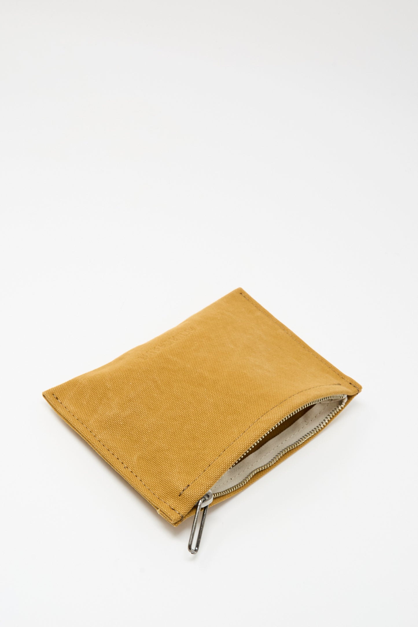 The Amiacalva Washed Canvas Medium Pouch in Mustard, featuring a rectangular shape and zip closure, is shown partially open against a plain white background.