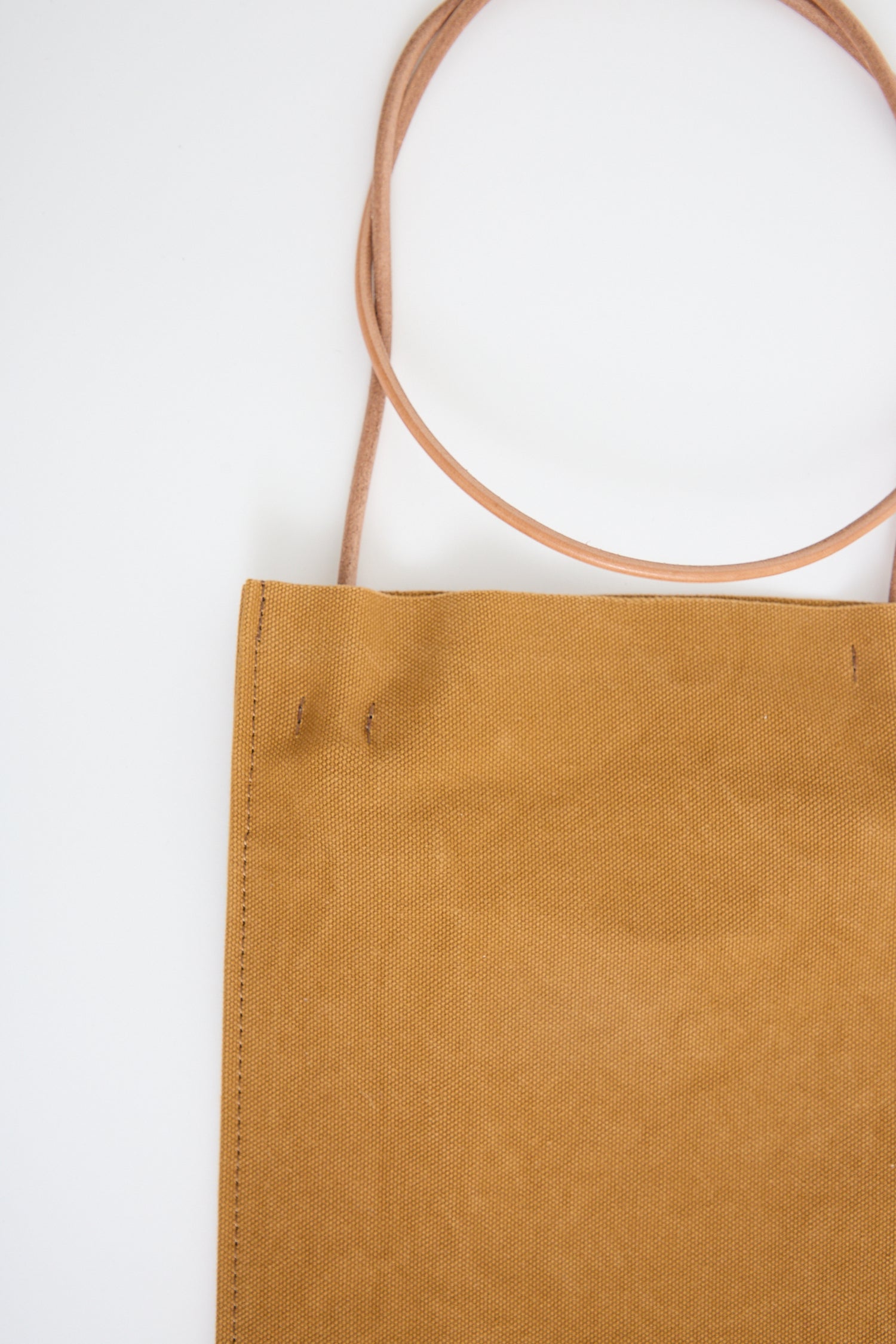 Brown Amiacalva washed canvas pochette in mustard on a white background. Up close. 