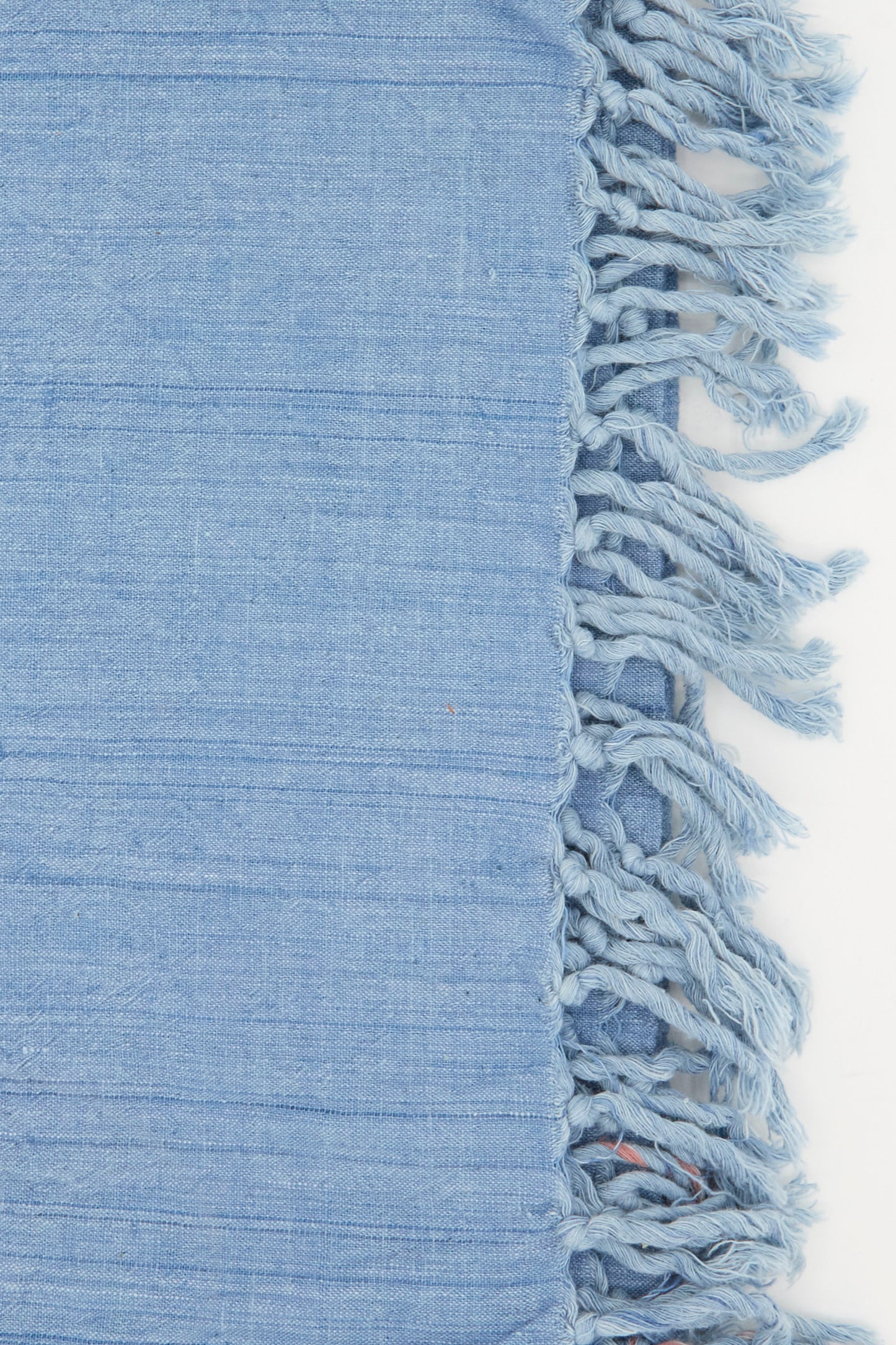 Close-up of Auntie Oti’s Cotton Khadi Red Selvedge Indigo Towel, featuring horizontal lines and fringed tassels on the right edge, set against a white background.
