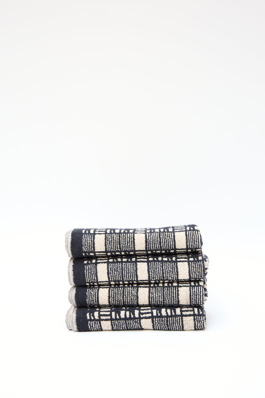 Stack of three folded Autumn Sonata Alma Hand Towels with a black and white plaid pattern, isolated on a white background.