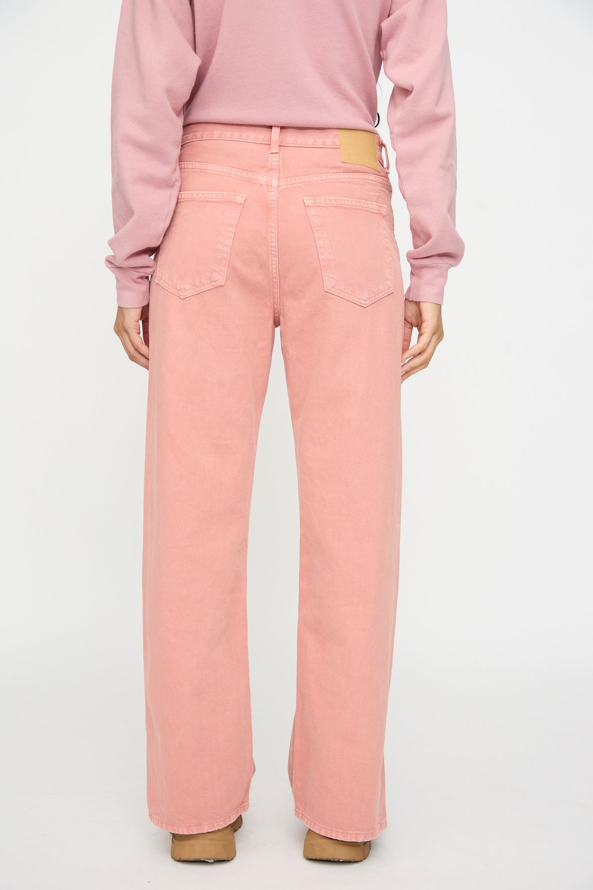 Person wearing a pink long-sleeve shirt and B Sides Charlot Split Hem in Myra Pink Overdye, shown from the back against a plain white background.