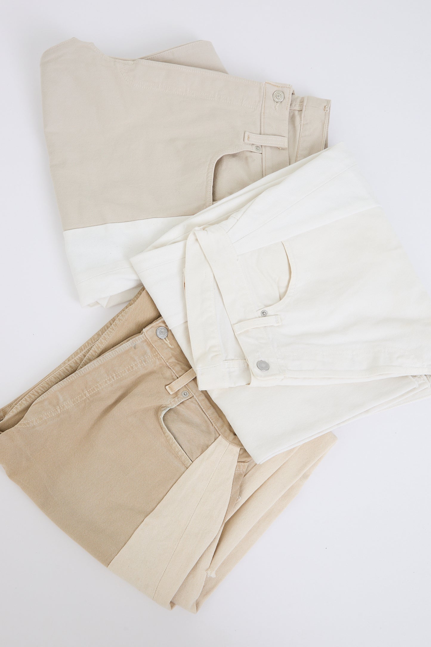 Folded beige Lasso Jeans in Vintage White by B Sides on a white background.