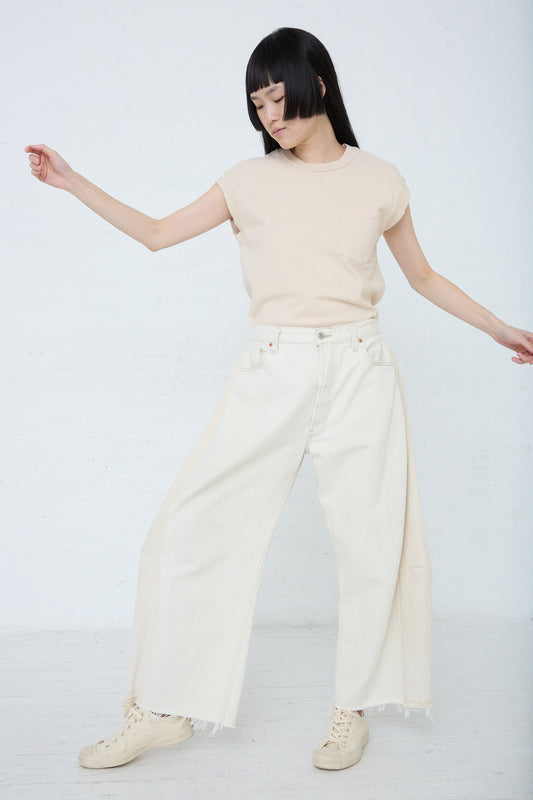 Woman posing in a B Sides Lasso Jean in Vintage White outfit with wide-leg pants and a casual top against a white background.