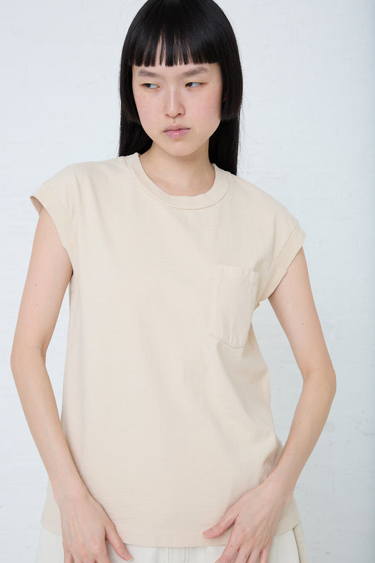 The model is wearing a beige cotton Pocket Tank in Tan Overdye by B Sides. Front view.