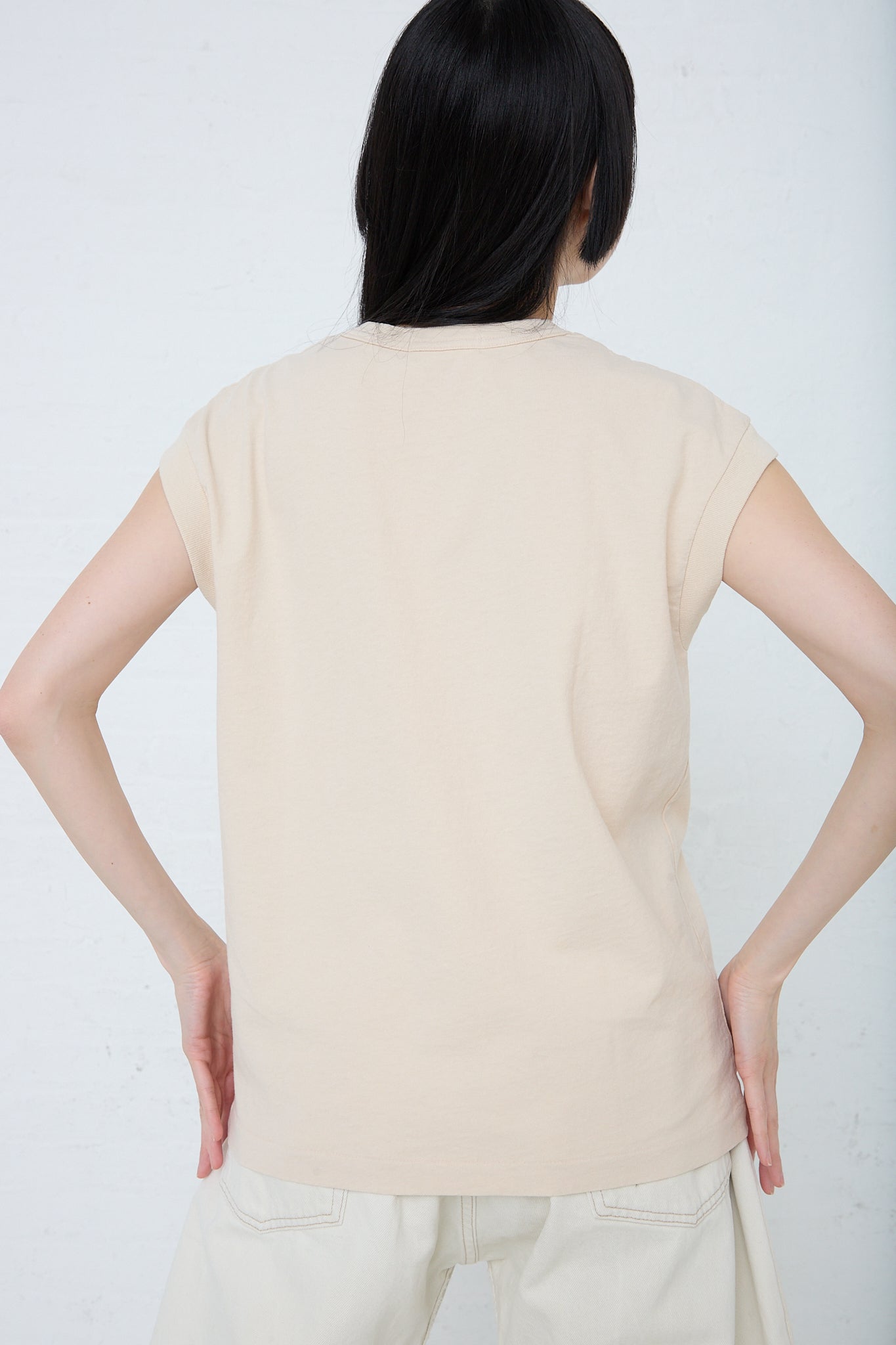 The back of a woman wearing a B Sides Pocket Tank in Tan Overdye.