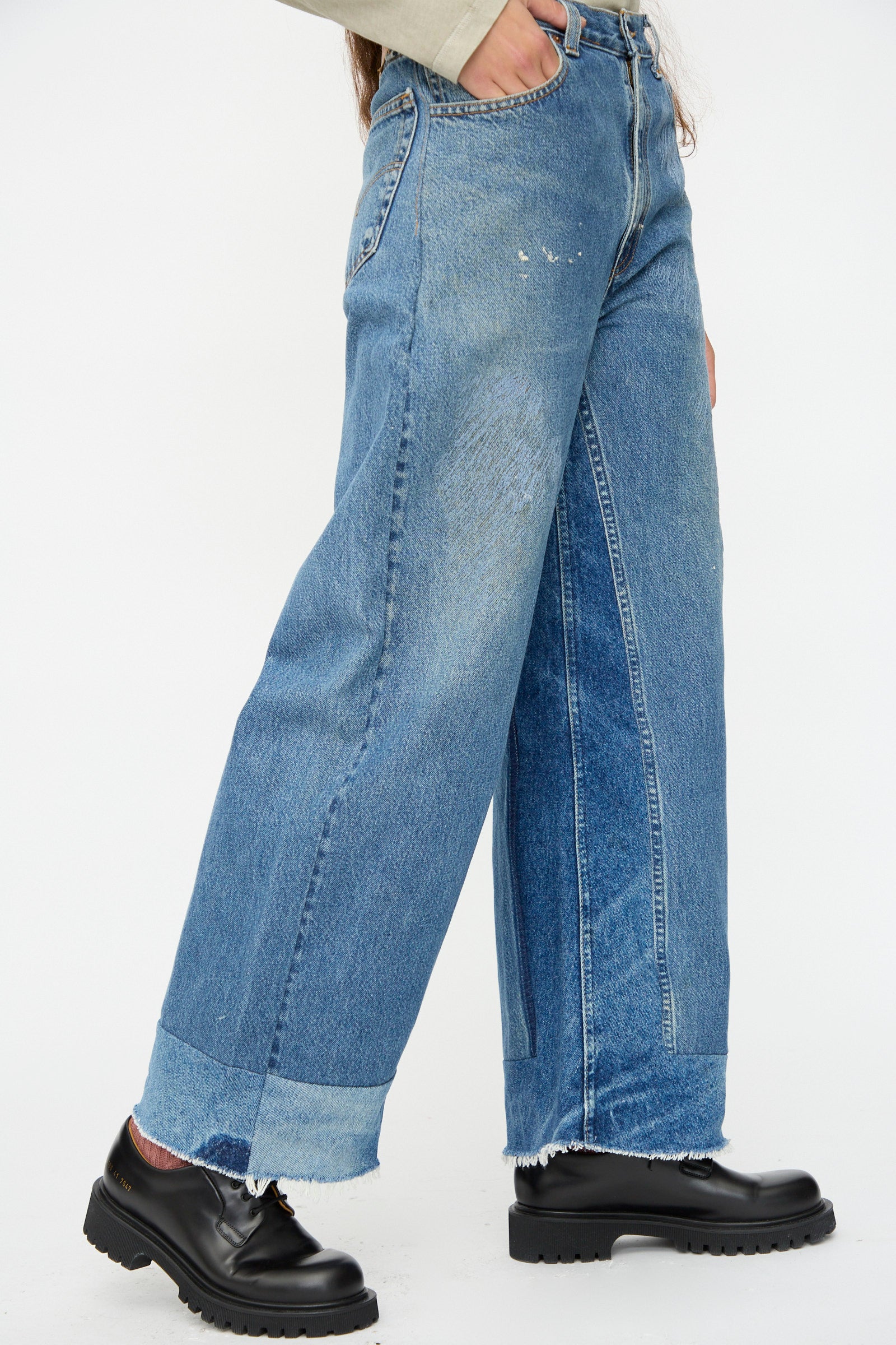 Model wears B Sides Reworked Culotte in Vintage Indigo, featuring a wide-leg, cuffed blue design with faded areas, paired with black chunky-soled shoes. Shown from hip to feet against a plain white background.