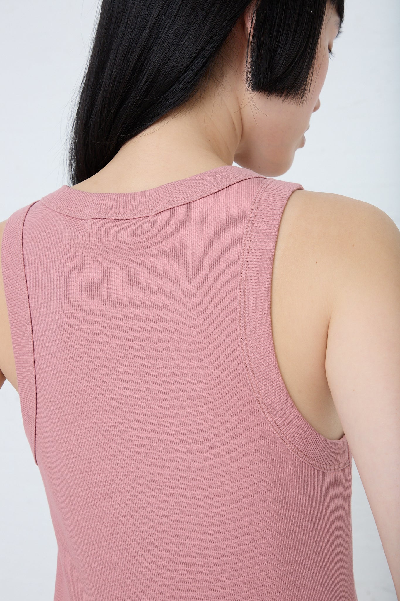 A woman is wearing a B Sides Rib Tank in Zinnia Overdye. Back view. Up close.