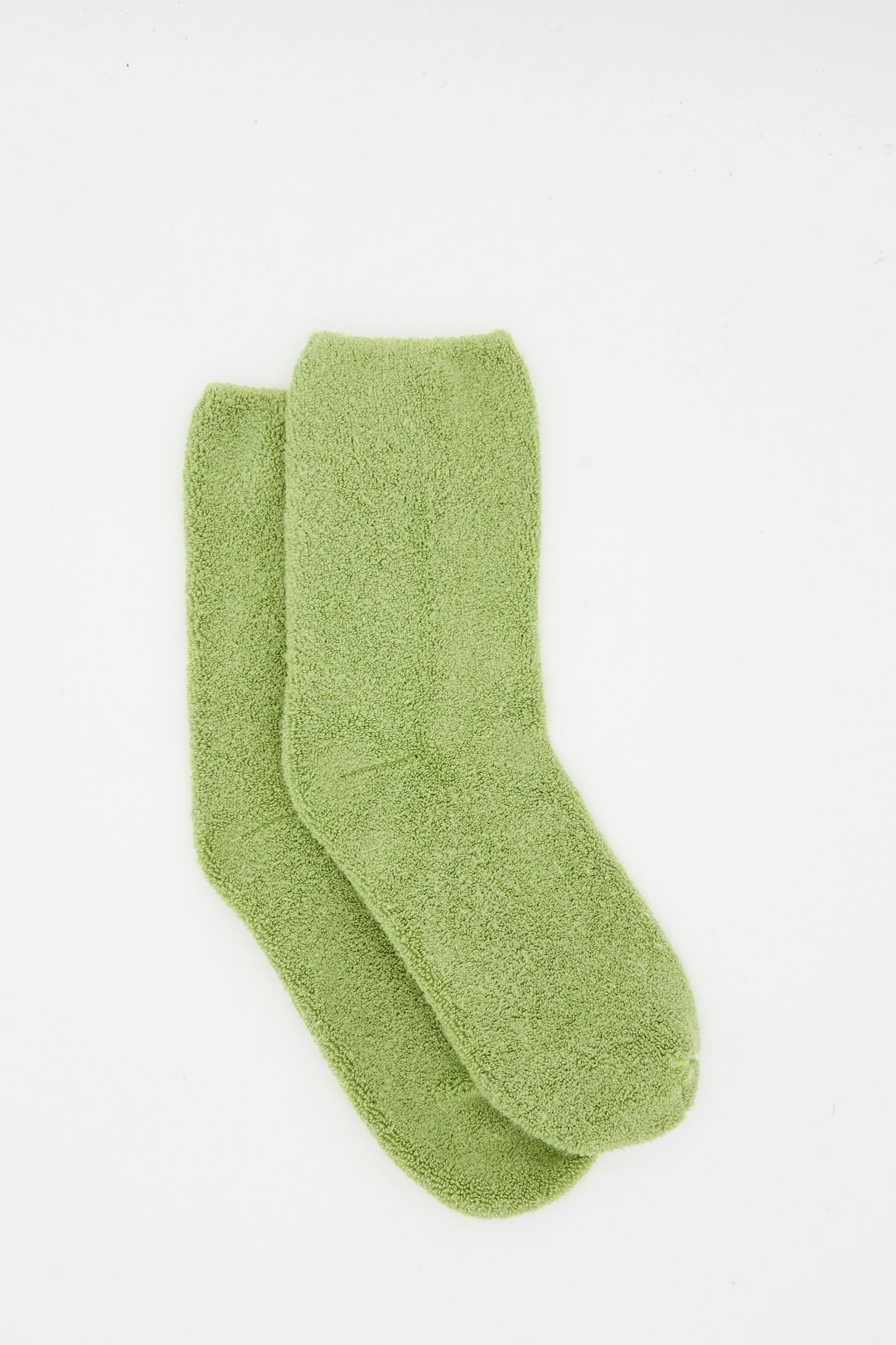 The Baserange Buckle Overankle Sock in Stroma Green, a light green fuzzy pair, is shown laid flat on a white background.