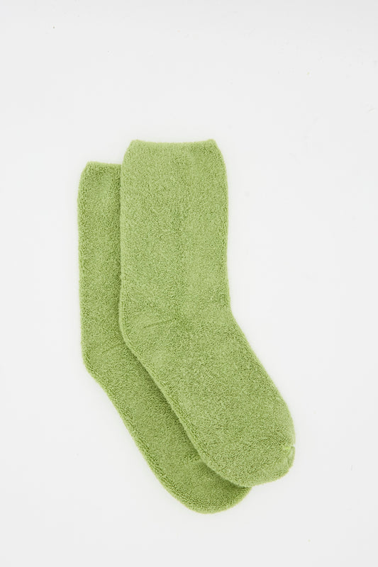 The Baserange Buckle Overankle Sock in Stroma Green, a light green fuzzy pair, is shown laid flat on a white background.