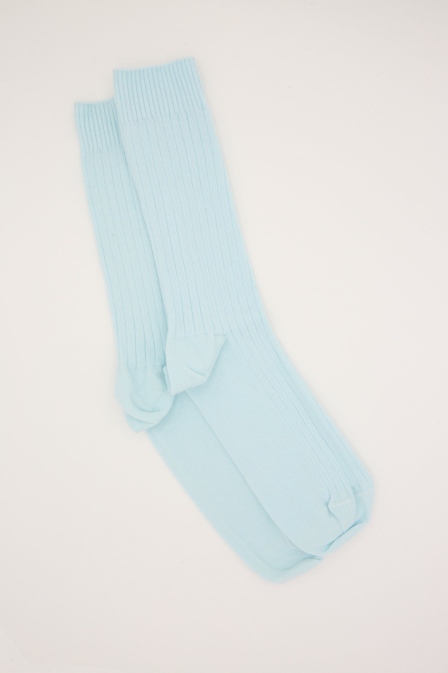 A pair of light blue knee-high Baserange socks, made from organic cotton, laid flat on a white background.