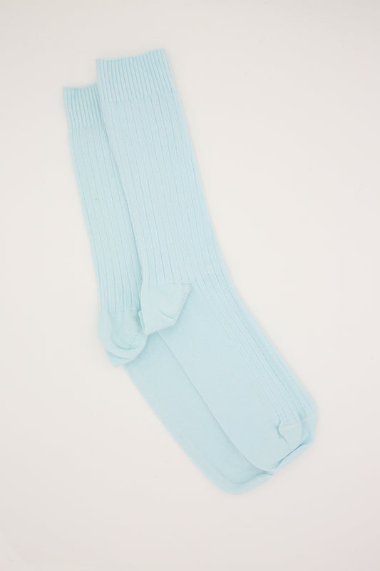 A pair of light blue knee-high Baserange socks, made from organic cotton, laid flat on a white background.