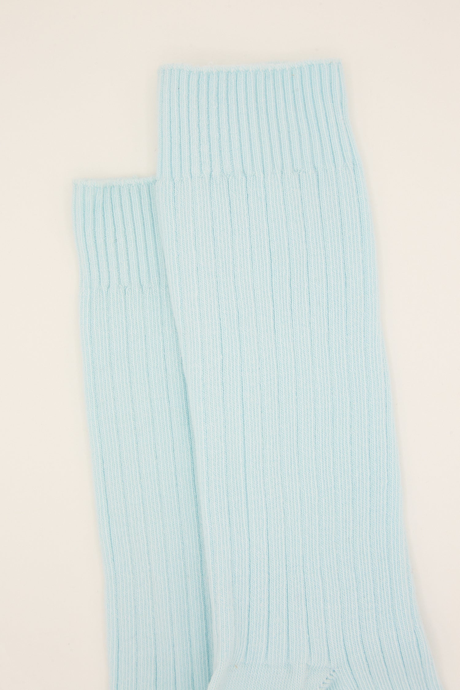 A pair of Cotton Rib Overankle Socks in Lagoon Blue by Baserange against a white background.