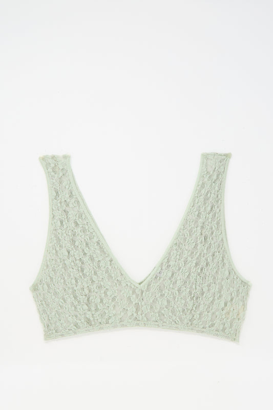 The Baserange Crescent Bra in Conta Green is a light green, soft organic cotton lace V-neck bra with a deep V-neckline, shown flat on a white background.