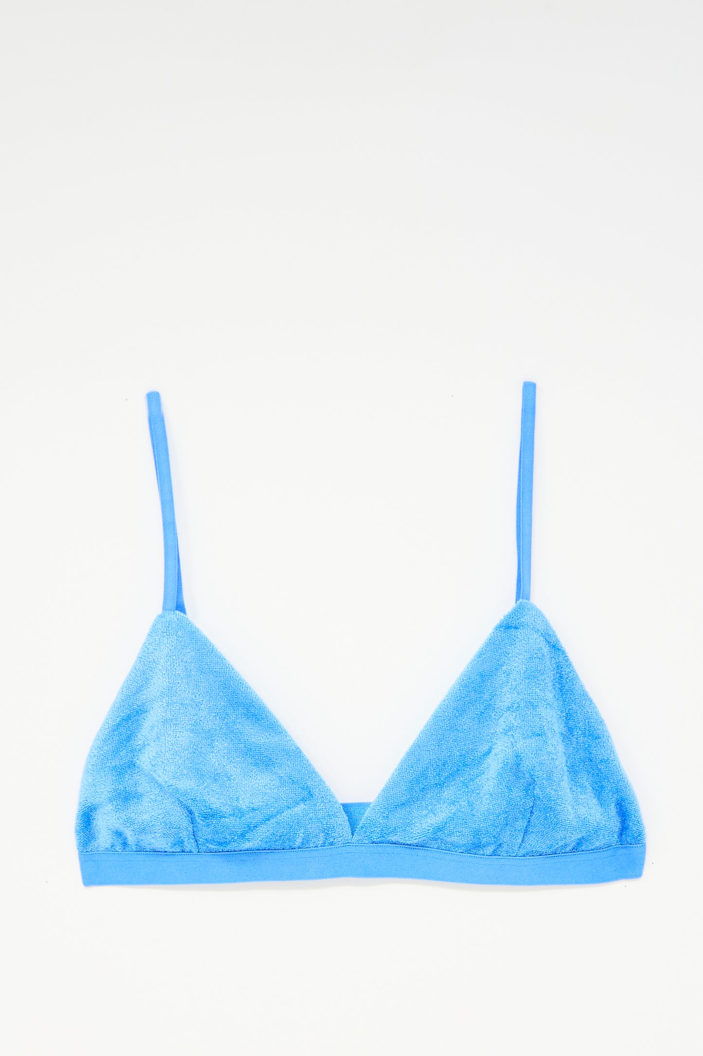 The Baserange Mississippi Bra in Zinn Blue, made from soft terry cloth with thin adjustable straps, is laid flat on a white background.