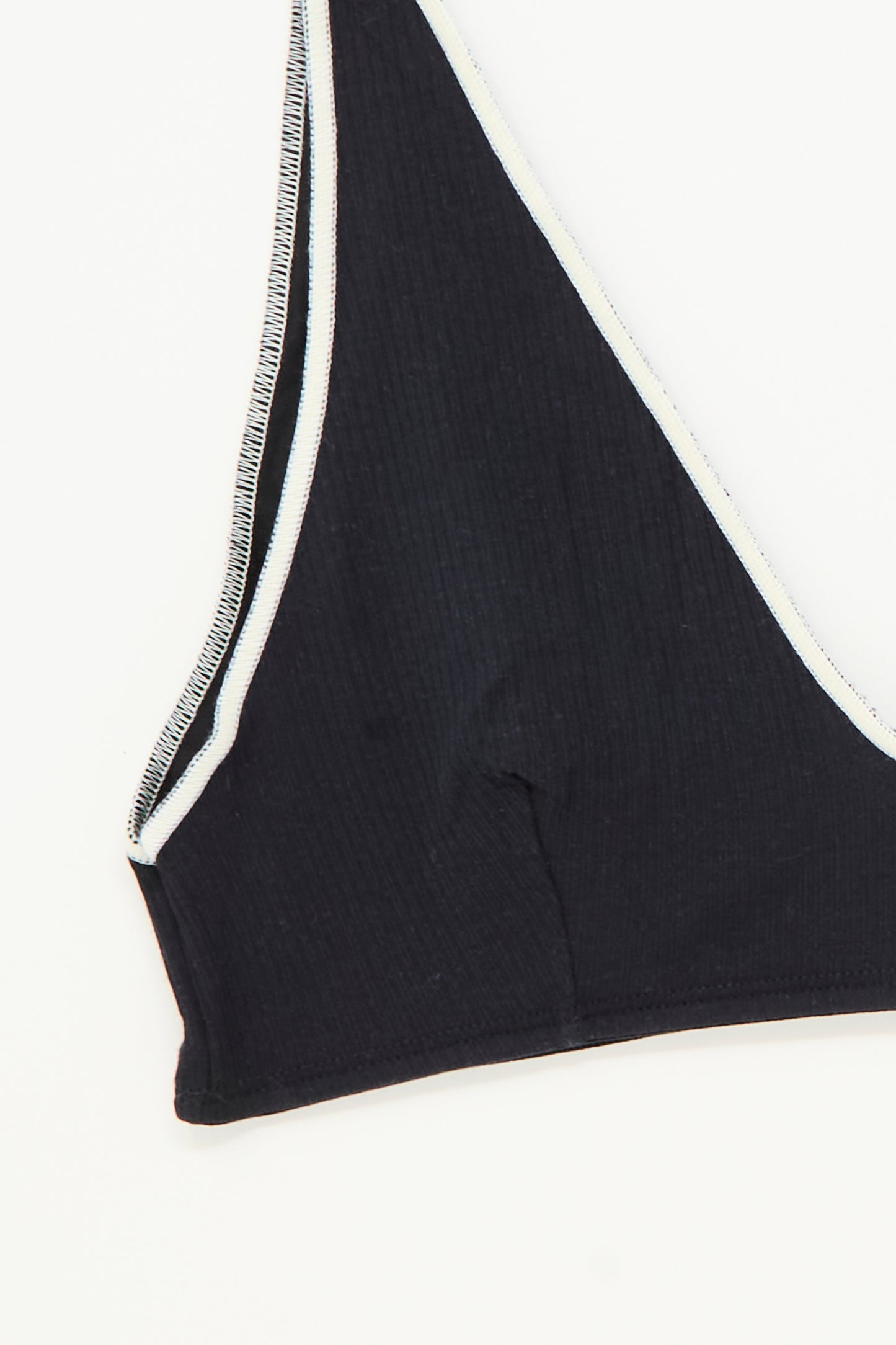 Close-up of the Pam Bra in Murano Navy by Baserange, featuring a black ribbed v-neck design with white trim against a white background.