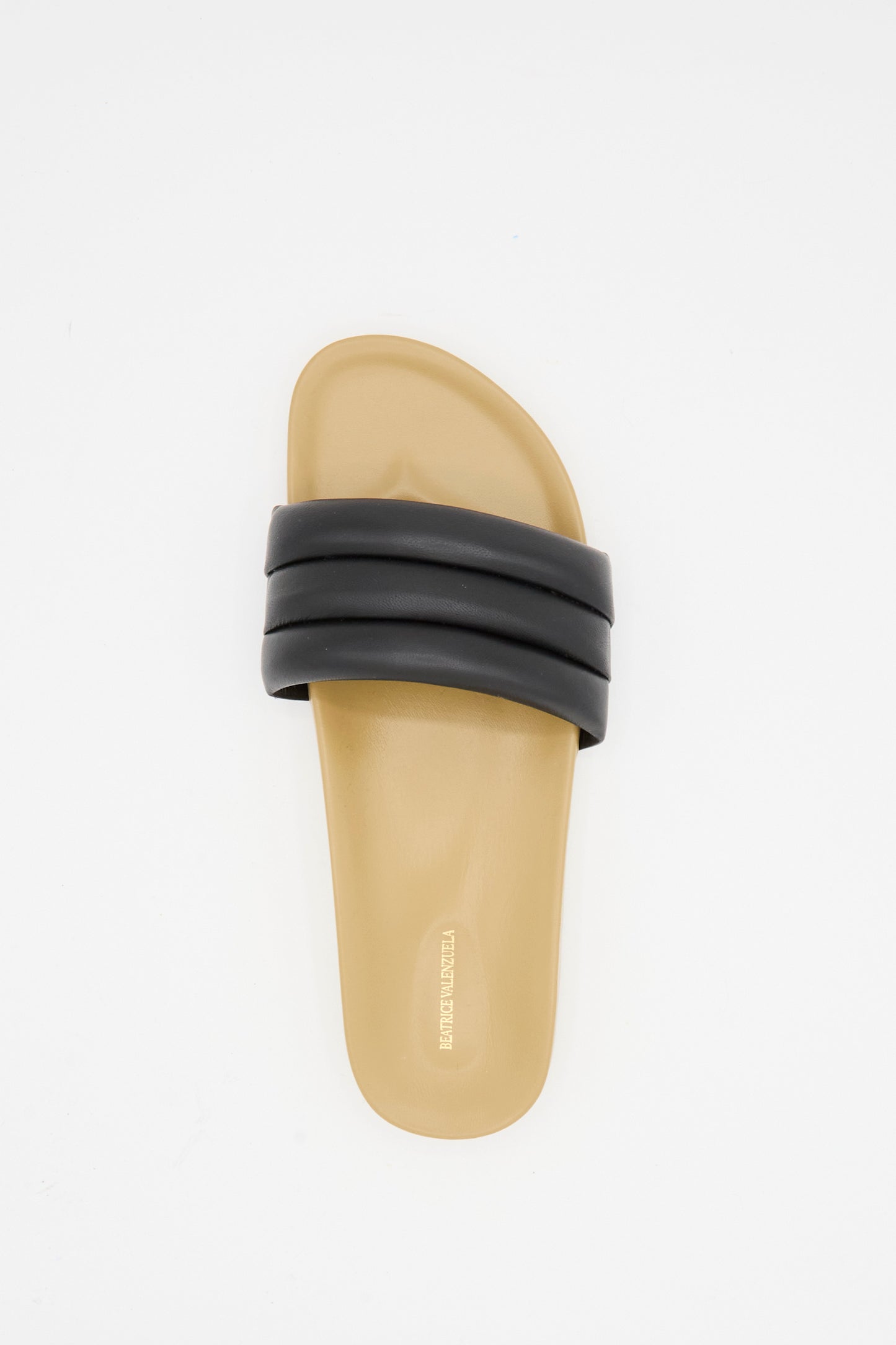 The Classic Sandalia in Black by Beatrice Valenzuela is a handcrafted slide sandal featuring a thick, black padded lambskin strap and tan sole, shown from above on a white background.