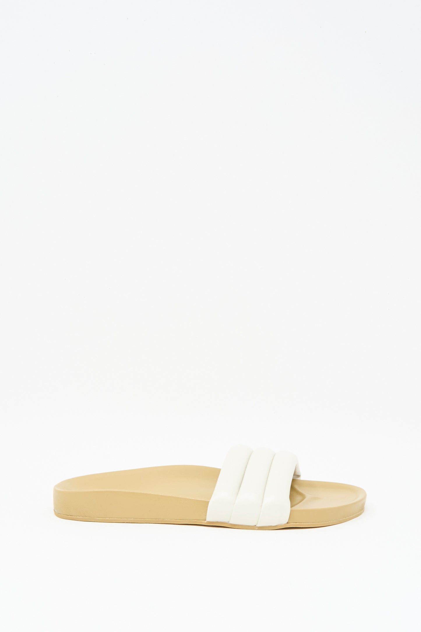 The Classic Sandalia in Shell by Beatrice Valenzuela is a beige handcrafted slide sandal featuring a thick, white padded strap, shown against a plain white background.