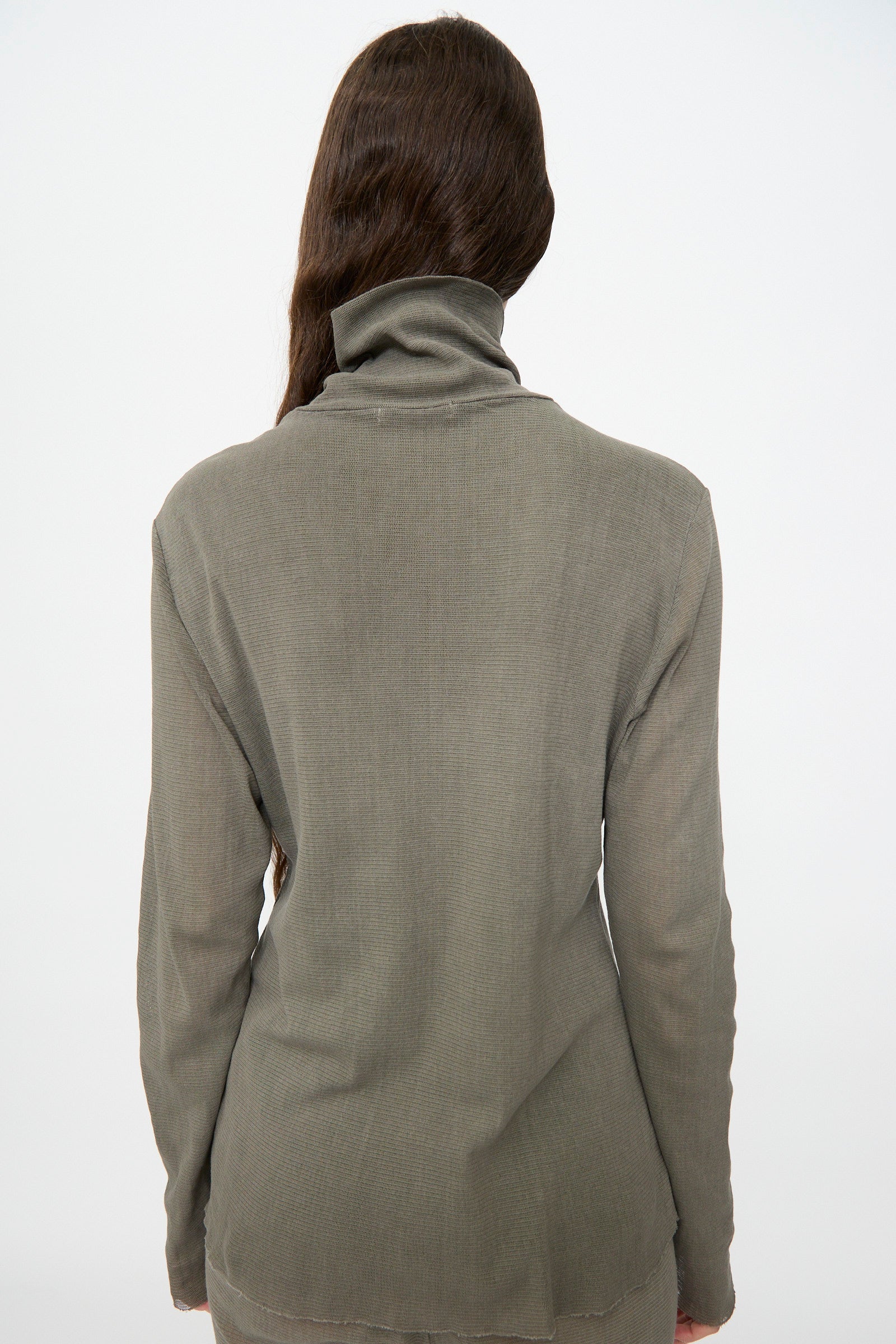 Person with long brown hair wears the Black Crane Double Mesh Turtleneck in Dark Stone, slim fit, viewed from behind against a plain light background.