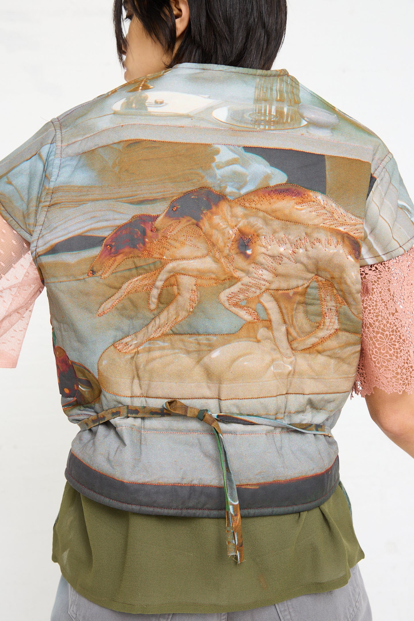 Person from behind wearing an oversized Bless cotton No. 77 Summer Living vest with a detailed crab design.