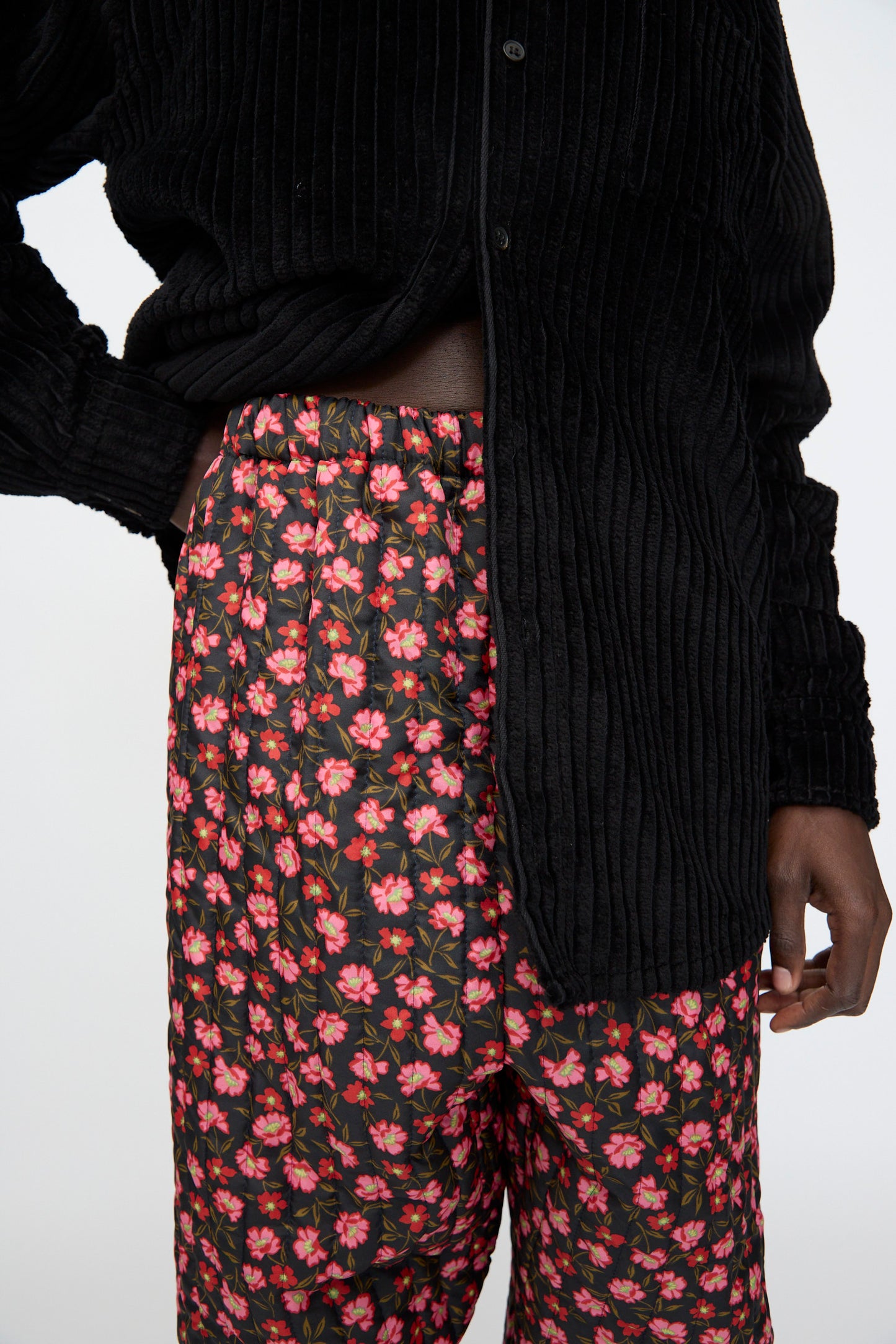 A person wears a black textured button-up shirt and Bless's No. 08 Monpe Pant in Floral Print IV, standing against a plain background.