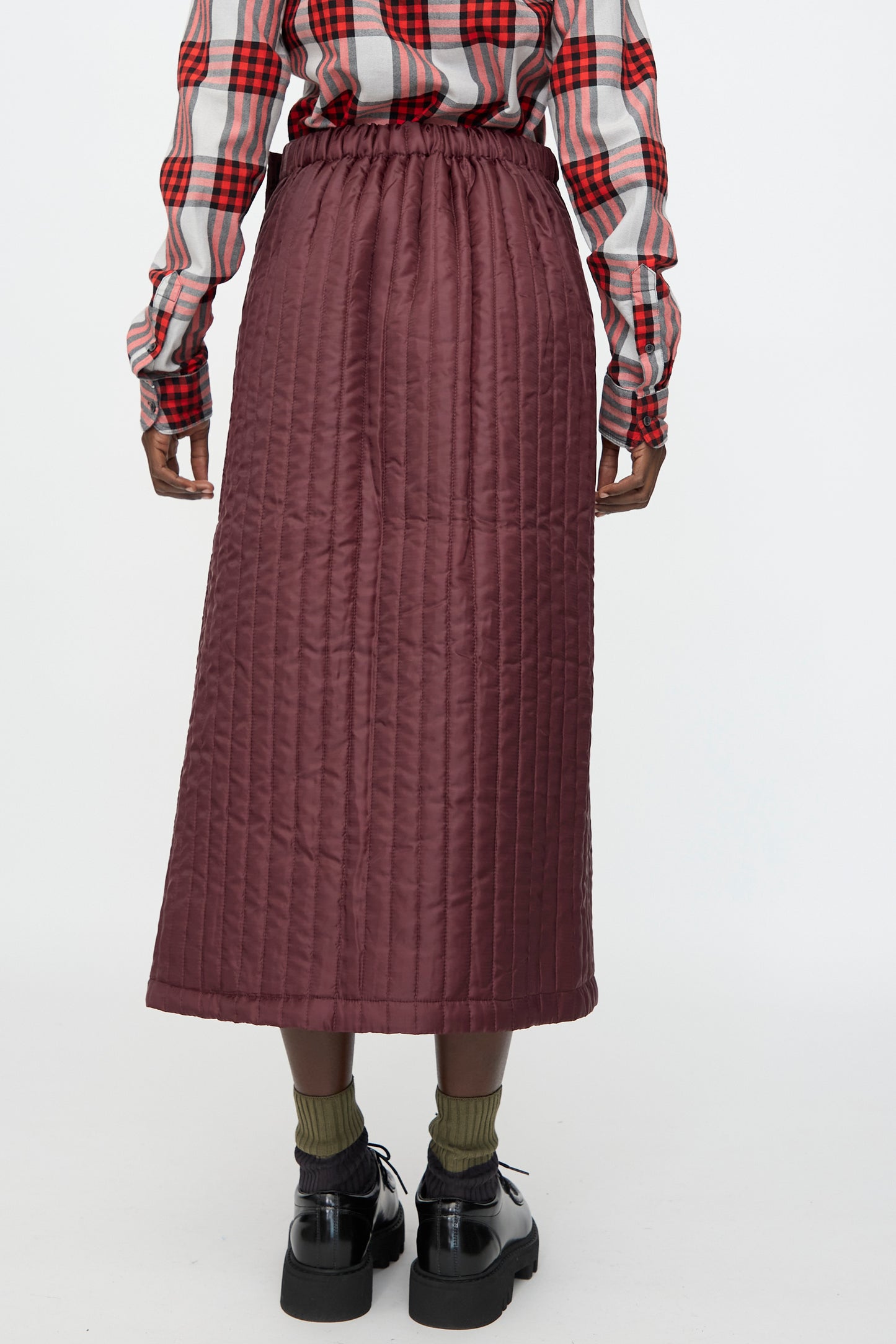 A woman wearing the Bless No. 08 Monpe Skirt in Burgundy, made in Germany.