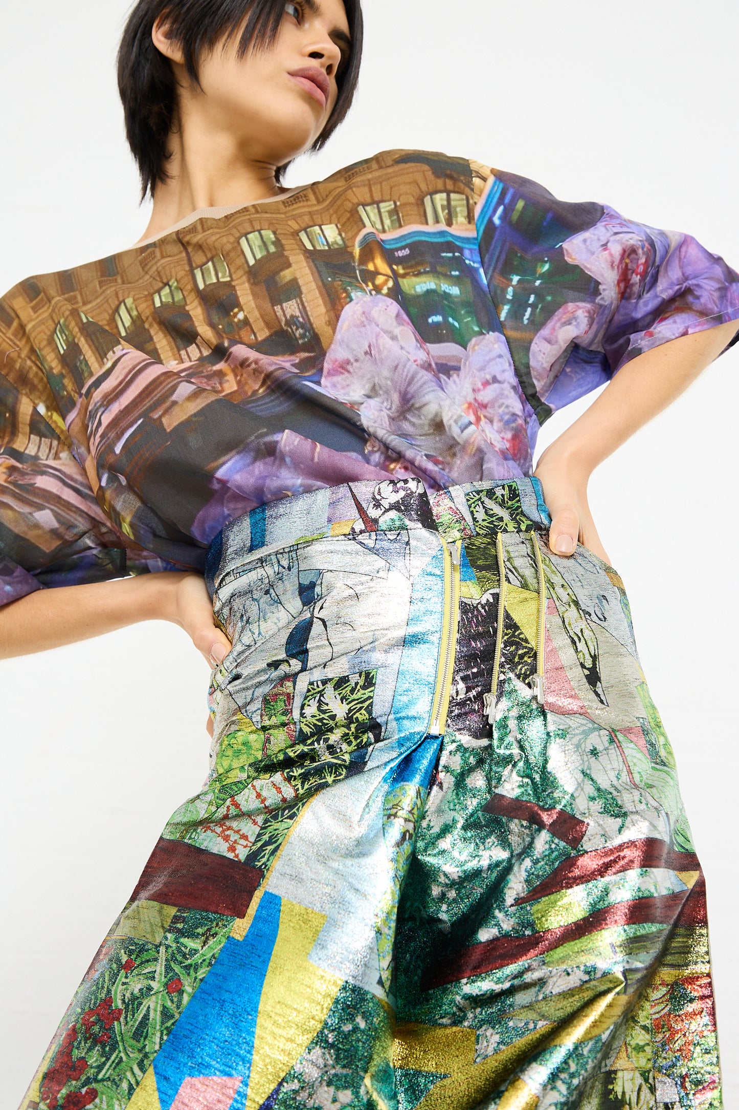 A person modeling a colorful, graphic print No. 77 SMLXL Skirt in Lurex Multicolor with an urban and floral design by Bless brand.