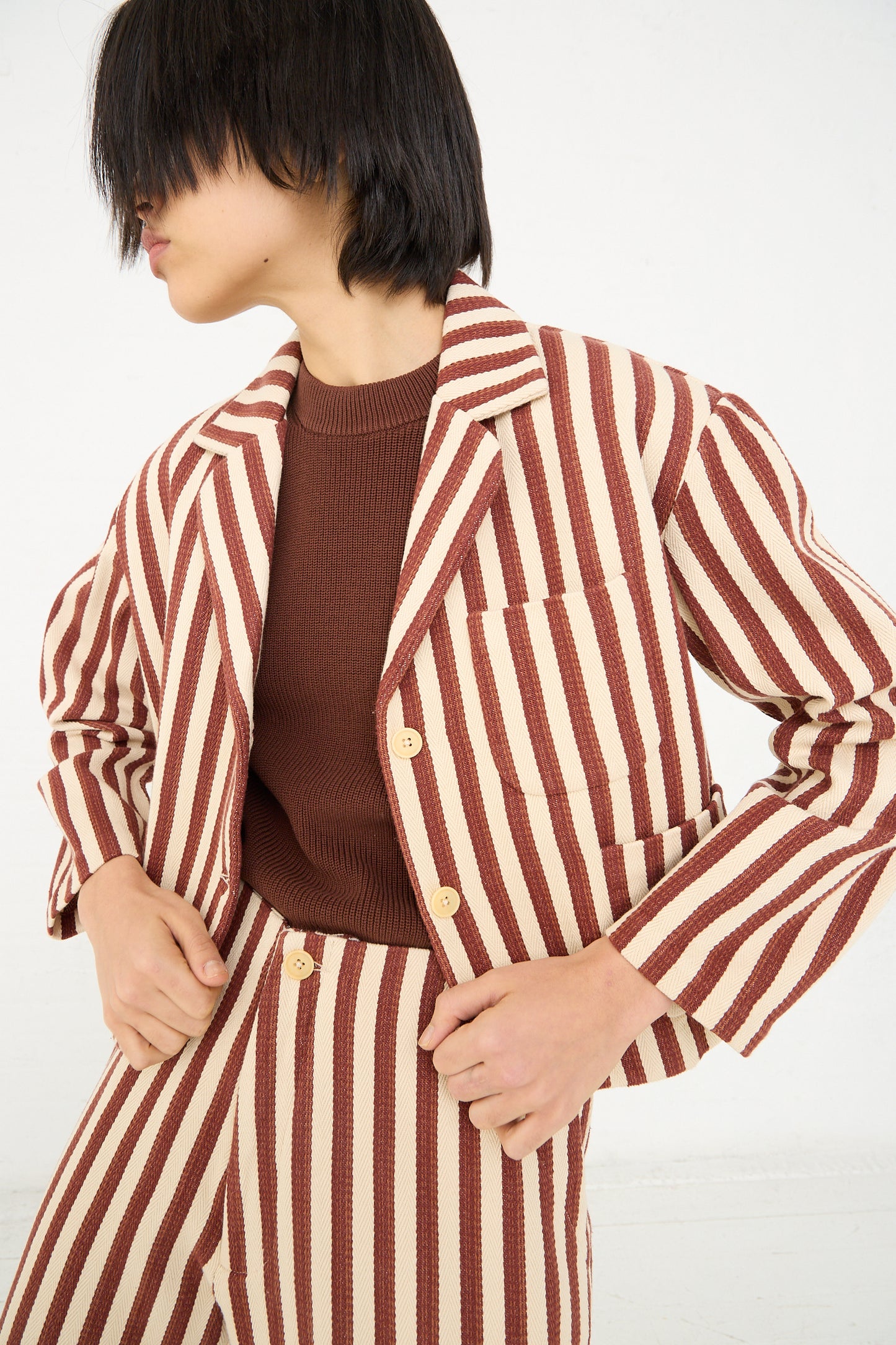 Person posing in a Caron Callahan Bernay Jacket in Auburn Stripe, with a coordinating outfit.