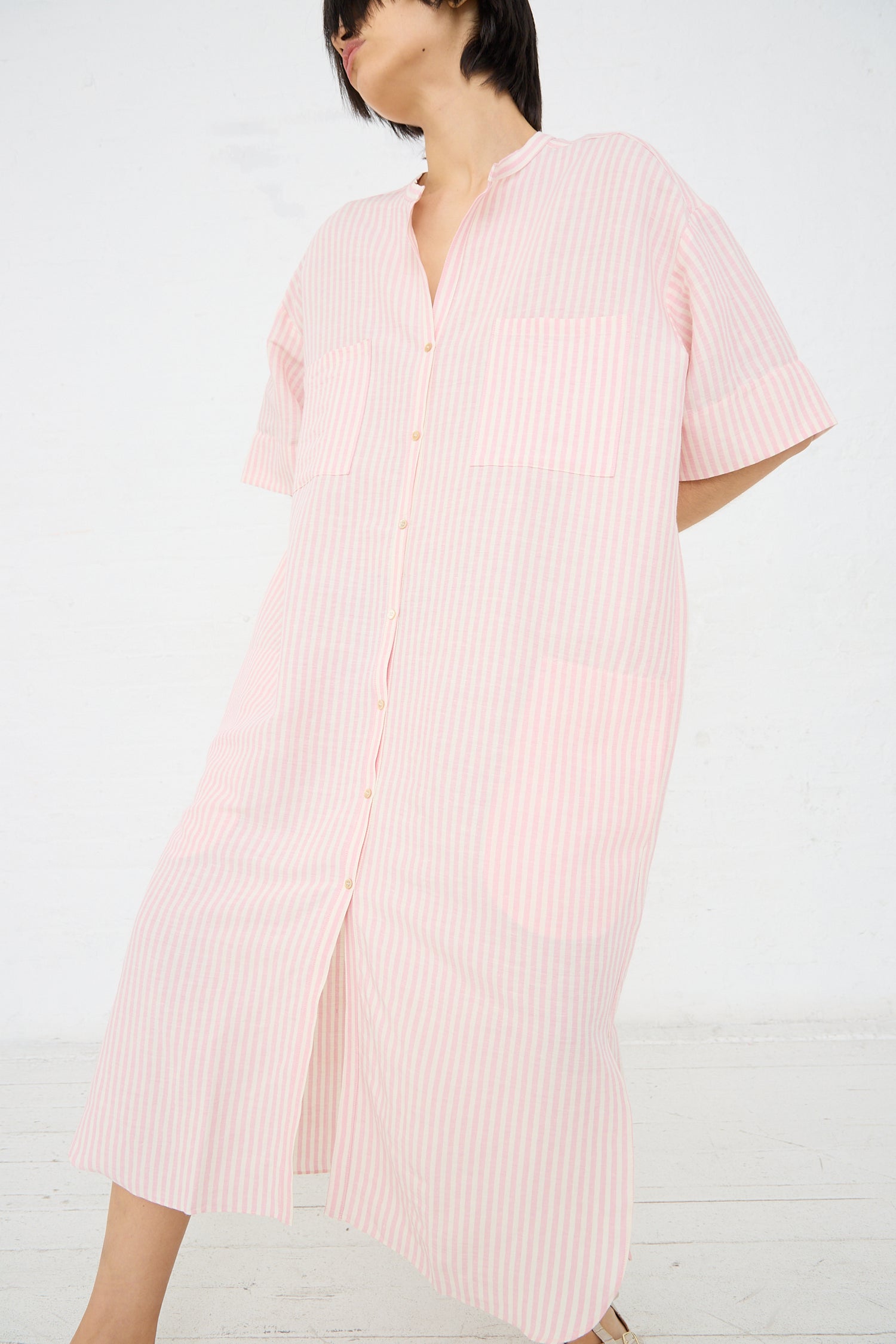 A person wearing a Caron Callahan Linen Stripe Kalloni Dress in Pink, standing against a white background.
