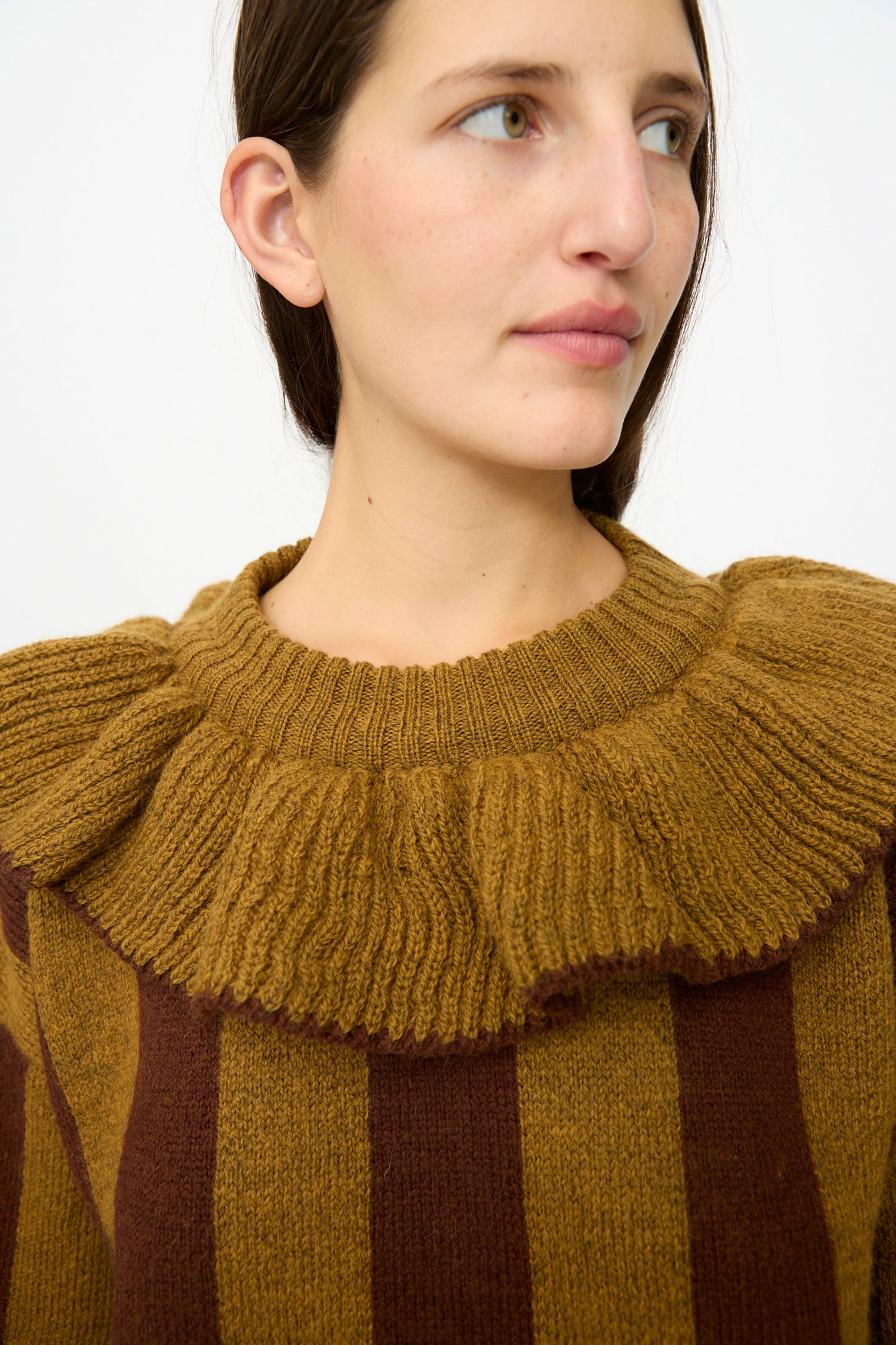 A woman wears the Cawley British Merino Wool Striped Ruffle Jumper in Goldfinch and Bordeaux, featuring a boxy fit and ruffled collar, against a plain light background.