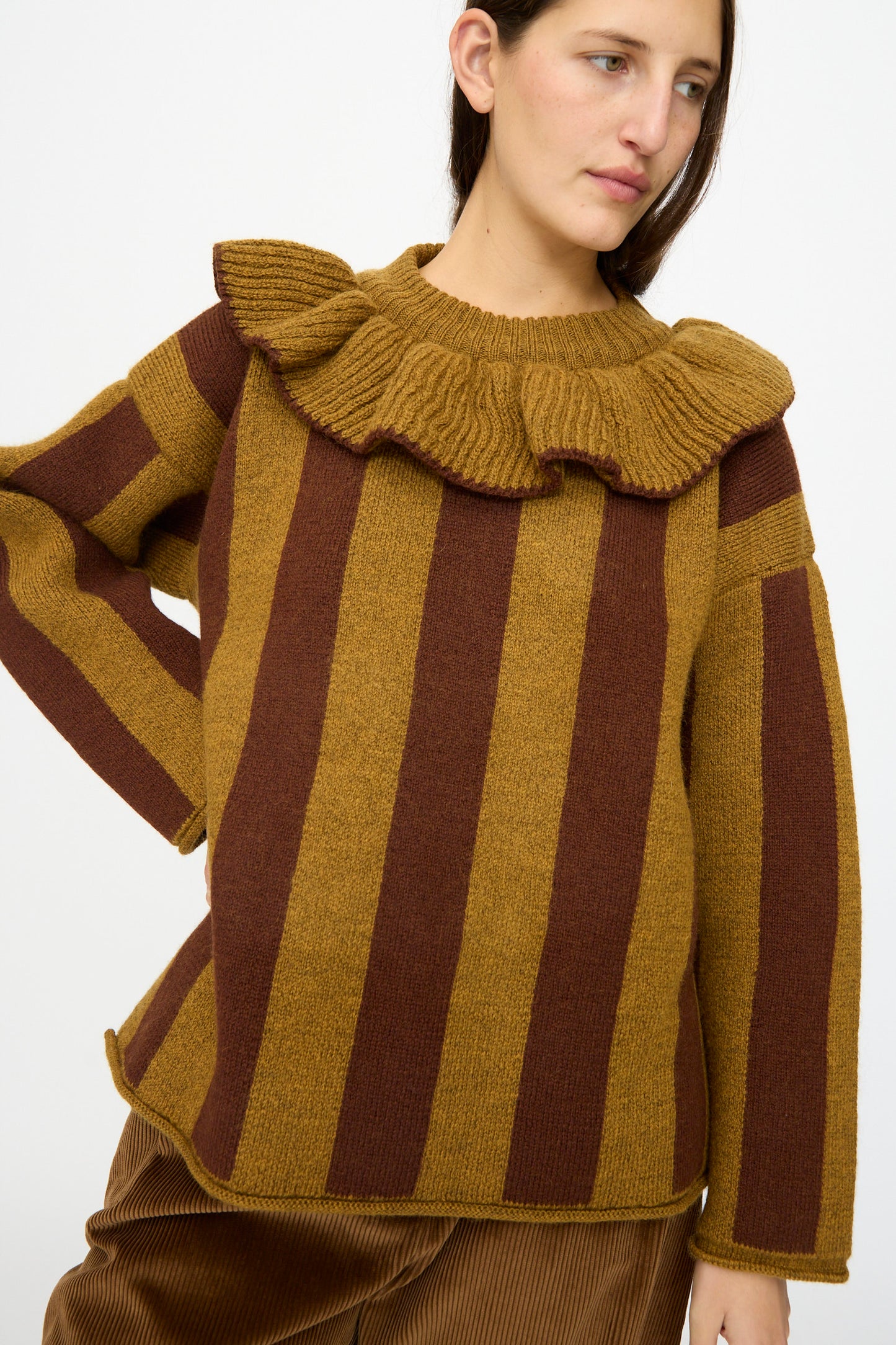 Model wears the Cawley British Merino Wool Striped Ruffle Jumper in Goldfinch and Bordeaux, featuring a ruffled collar, against a plain white background.