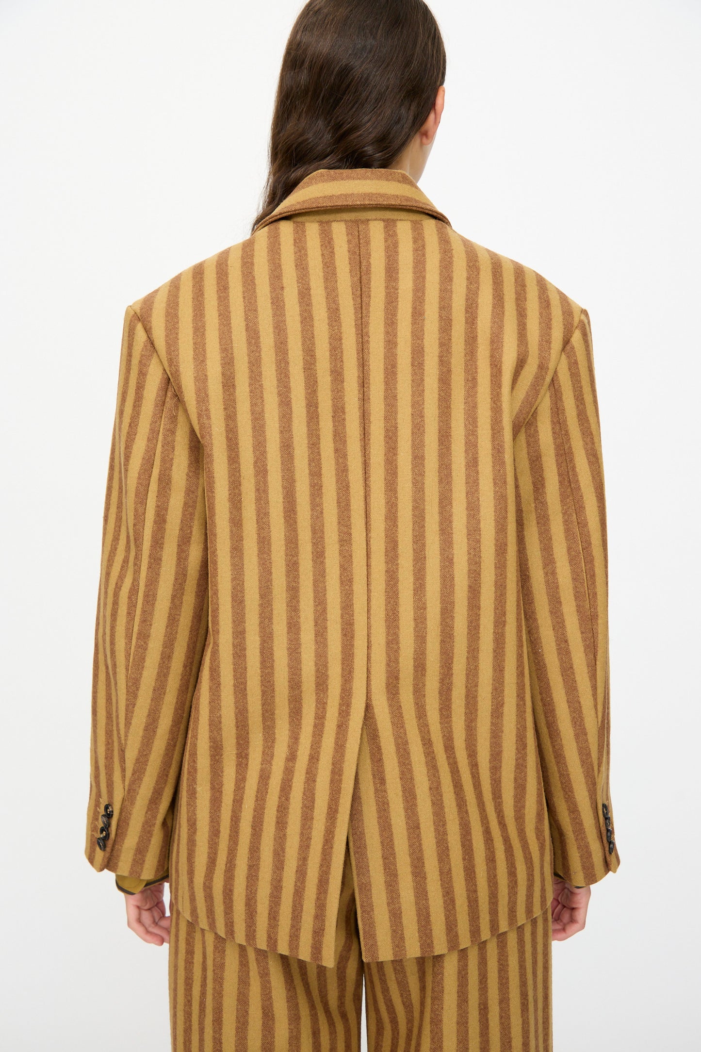 Person shown from the back wearing the Cawley Portuguese Striped Wool Andie Blazer in Goldfinch and Bordeaux with matching pants, set against a plain background.