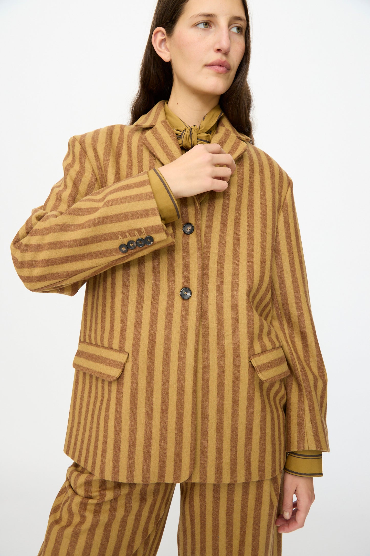 Model wearing the Cawley Portuguese Striped Wool Andie Blazer in Goldfinch and Bordeaux, paired with a matching shirt, standing against a plain white background.