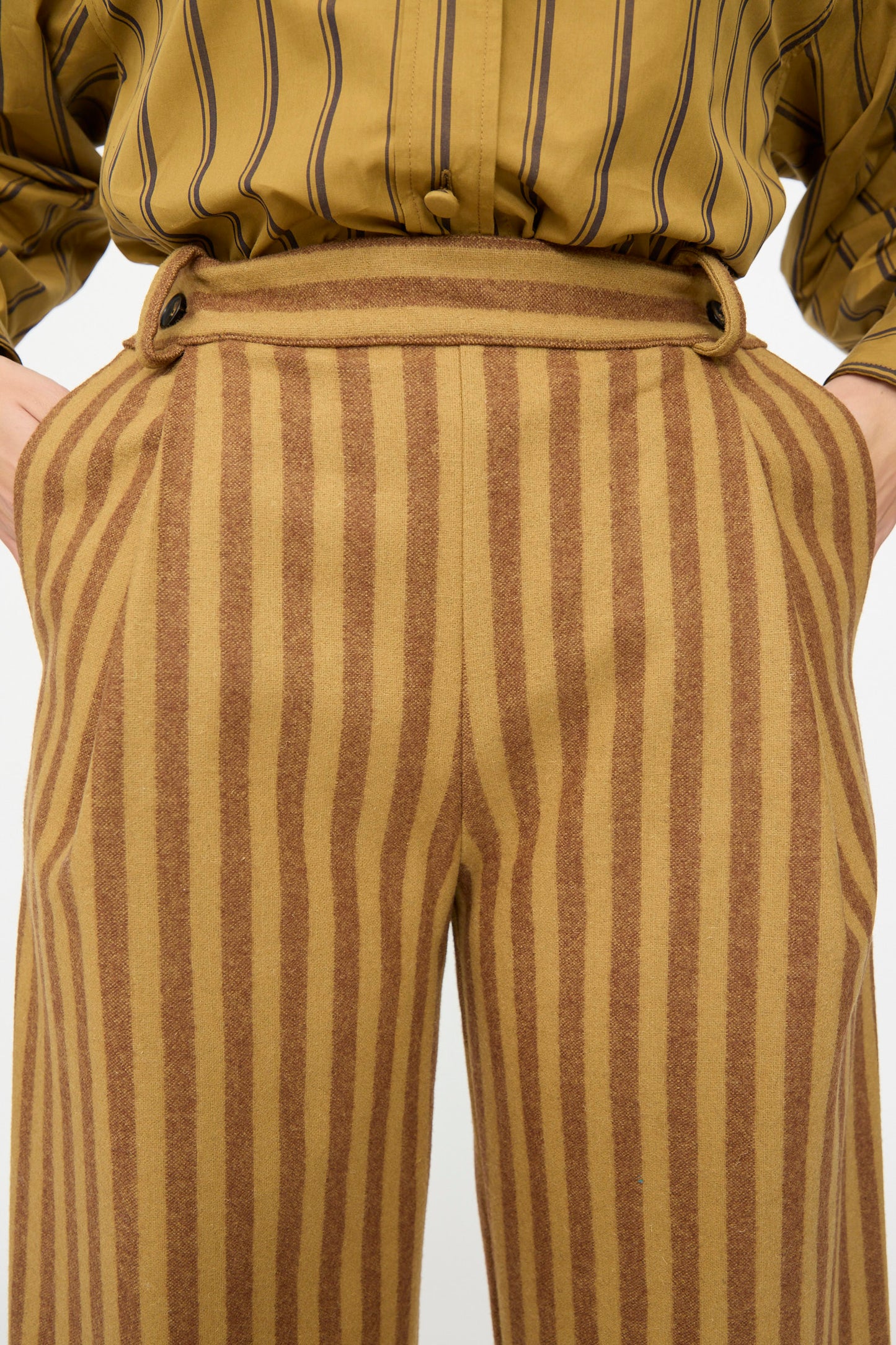 Person wearing Cawley Portuguese Striped Wool Georgia Trouser in Goldfinch and Bordeaux with hands in pockets, paired with a matching striped shirt, both made in London.