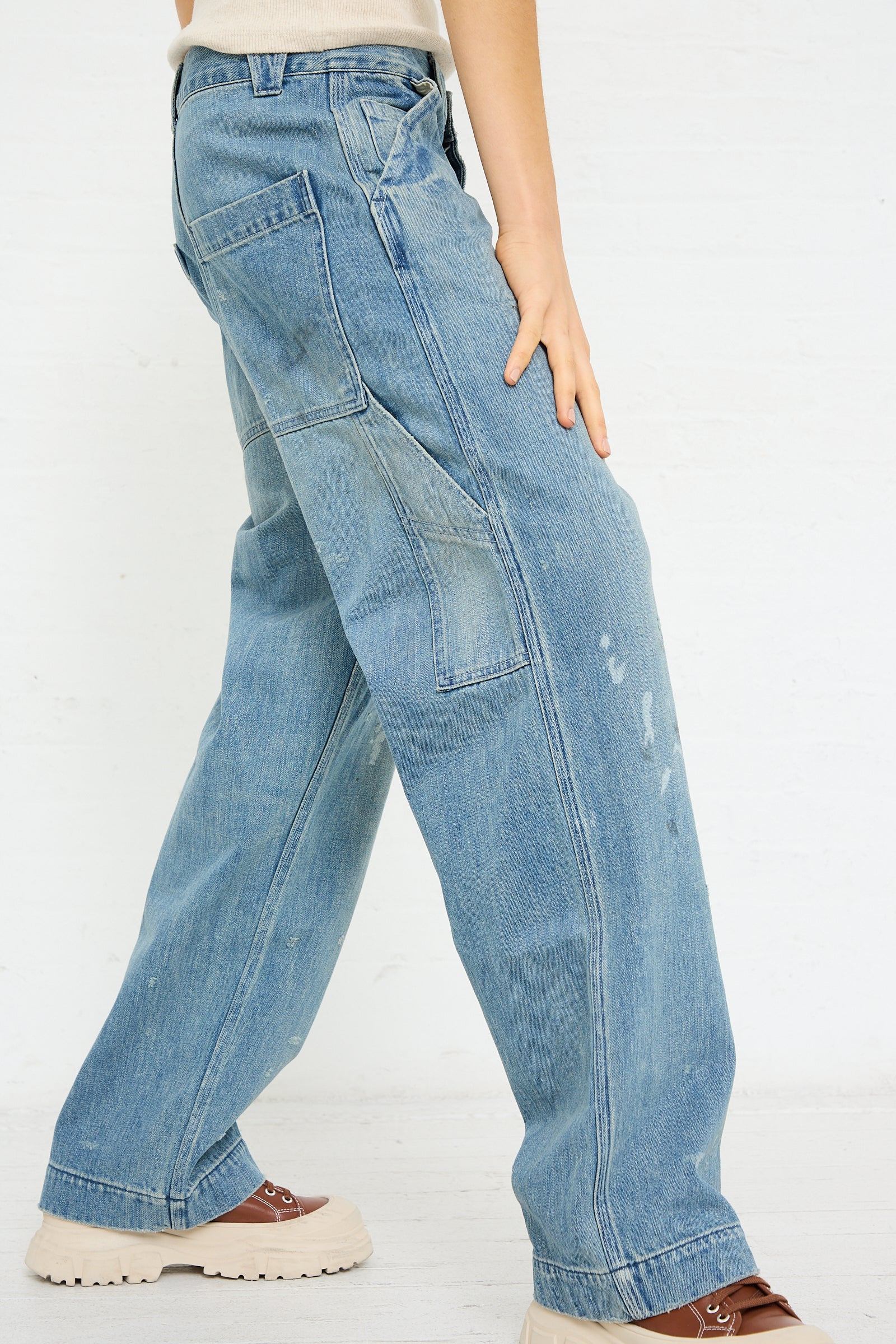 A person wearing Chimala's Denim Painter Pant in Vintage Wash and two-tone shoes.
