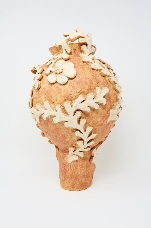 The Le Jardin Suspendu Tall Amphora Vase by Clandestine is a rustic brown ceramic piece with beige floral and leaf appliqué detailing, showcasing delicate motifs, photographed against a plain white background.