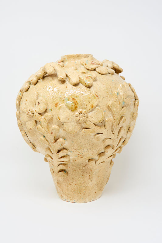 The Le Jardin d'Eden Wide Amphora Vase by Clandestine features a beige ceramic, rounded body with raised floral and leaf designs, made from natural clay and displayed on a plain white background.