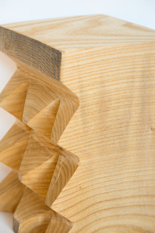 A close up of a handmade piece of wood from a Kingston Ash II Side Table with spikes on it by Cody Brgant.