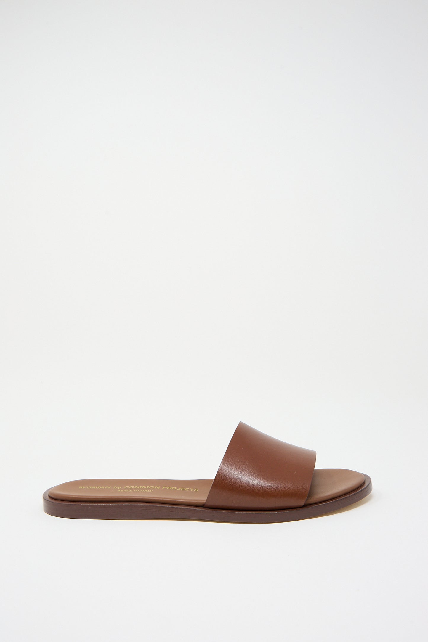 Brown Nappa Leather Slide Sandal by Common Projects on a white background.