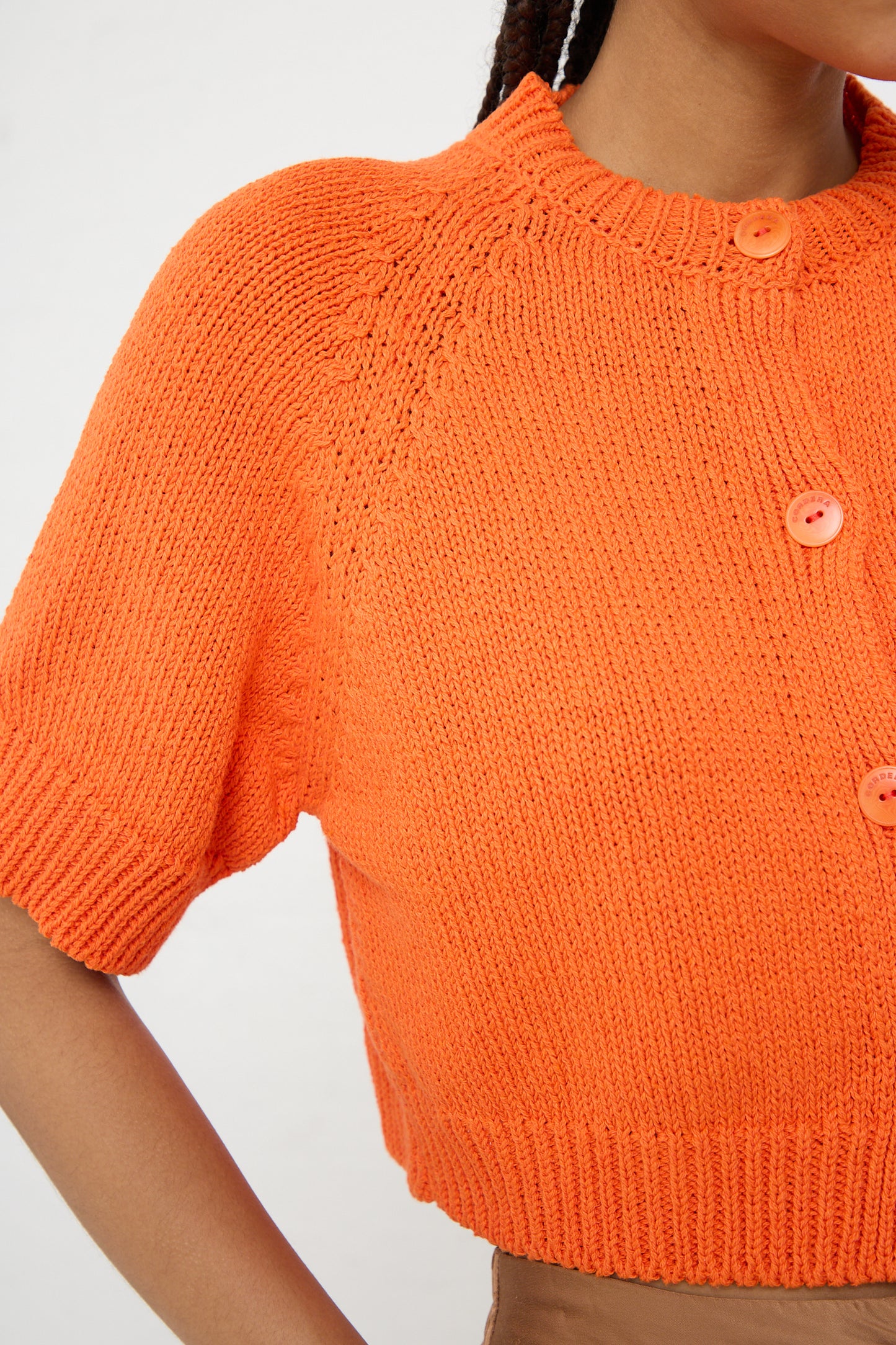 Close-up of a person wearing a Mandarina Cotton Knit Buttoned Top by Cordera made in Spain.