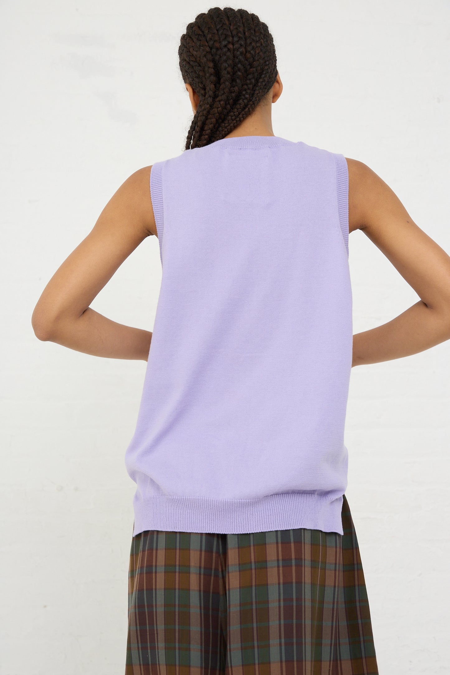 A person from behind wearing a purple sleeveless Organic Cotton Tank Top in Cardo and plaid trousers by Cordera.