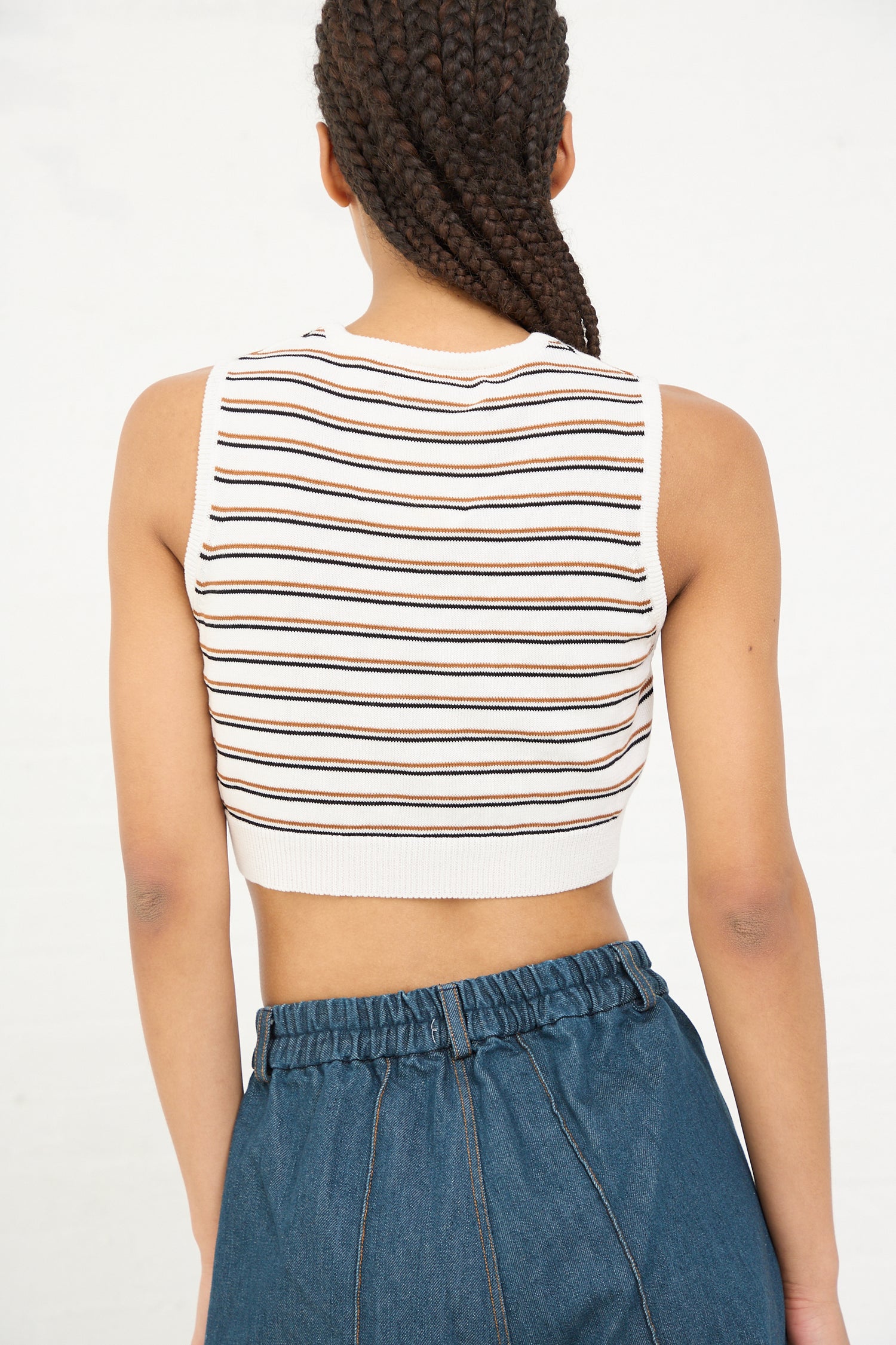 Woman seen from behind wearing a Cordera organic cotton striped crop top with a braid hairstyle.