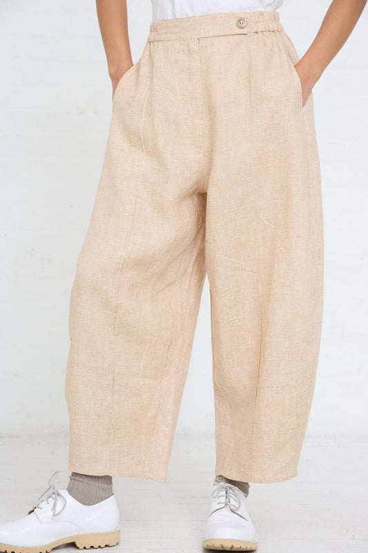 Person wearing Cordera Linen Curved Pant in Melange and white shoes standing against a white background.
