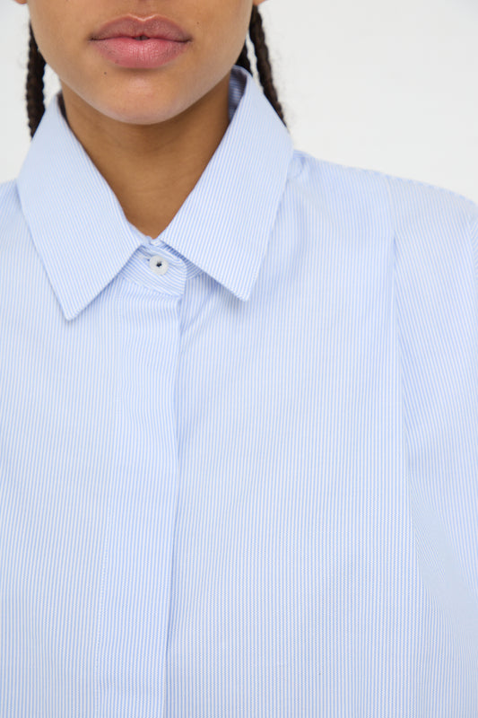 Close-up of a person in an oversized Cordera Organic Oxford Shirt in Blue with collar details.