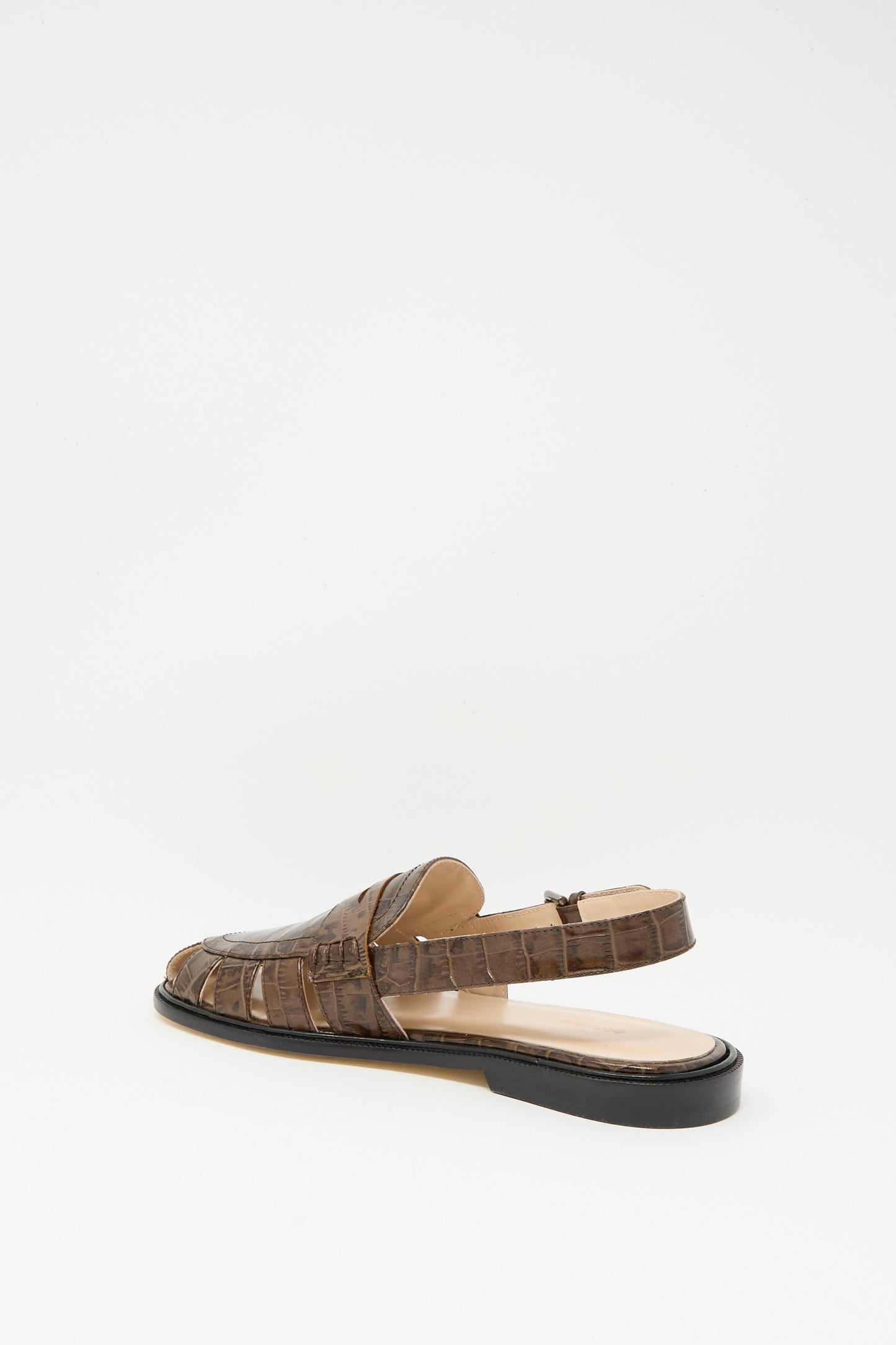The Slingback Loafer in Crocodile by Cordera features a brown crocodile pattern, closed toe, open back, and low black heel. Expertly crafted in Spain, it’s shown on a plain white background.