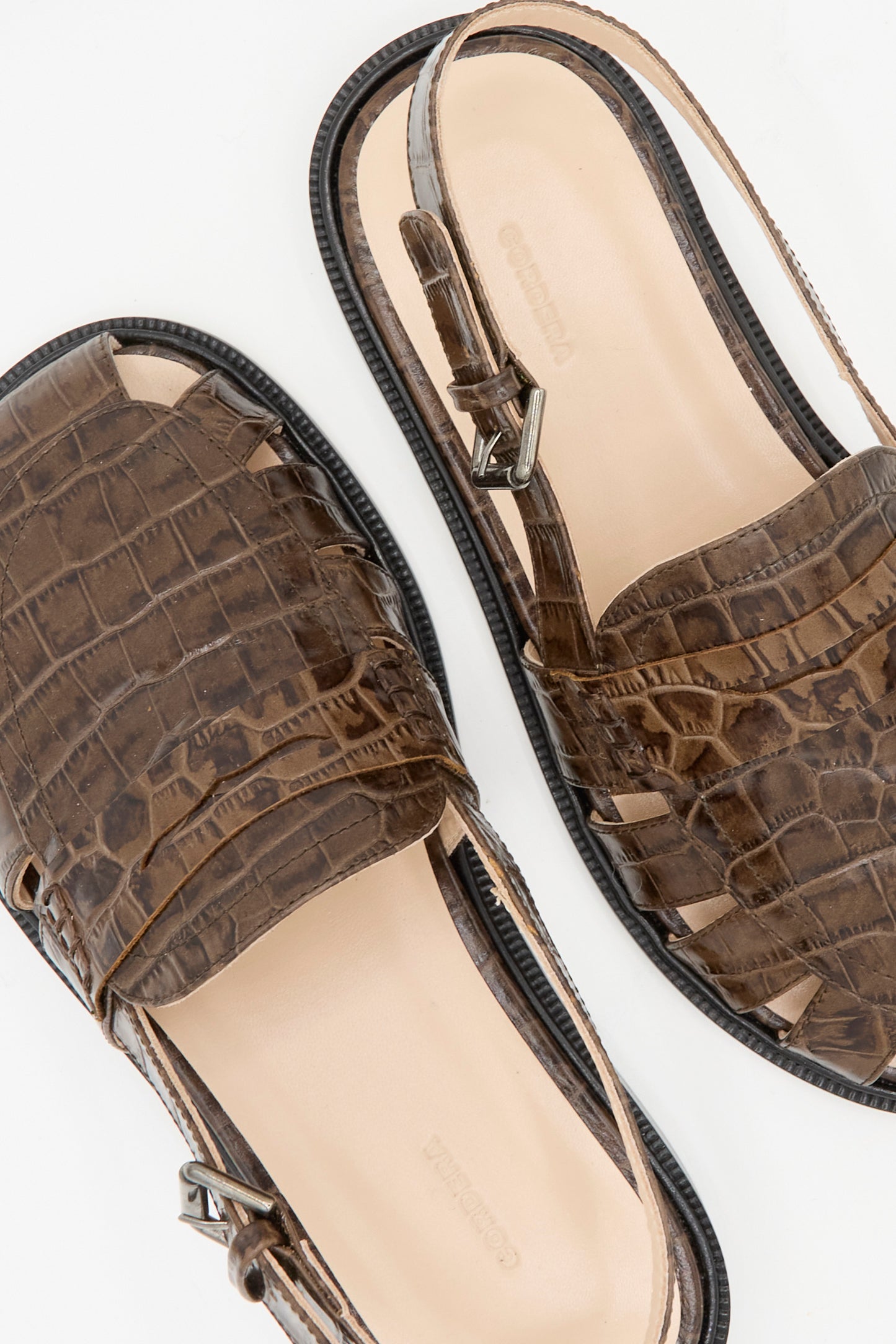 Close-up of Cordera's Slingback Loafer in Crocodile, showcasing brown crocodile leather with slingback straps and open sides, made in Spain, displayed on a white background.