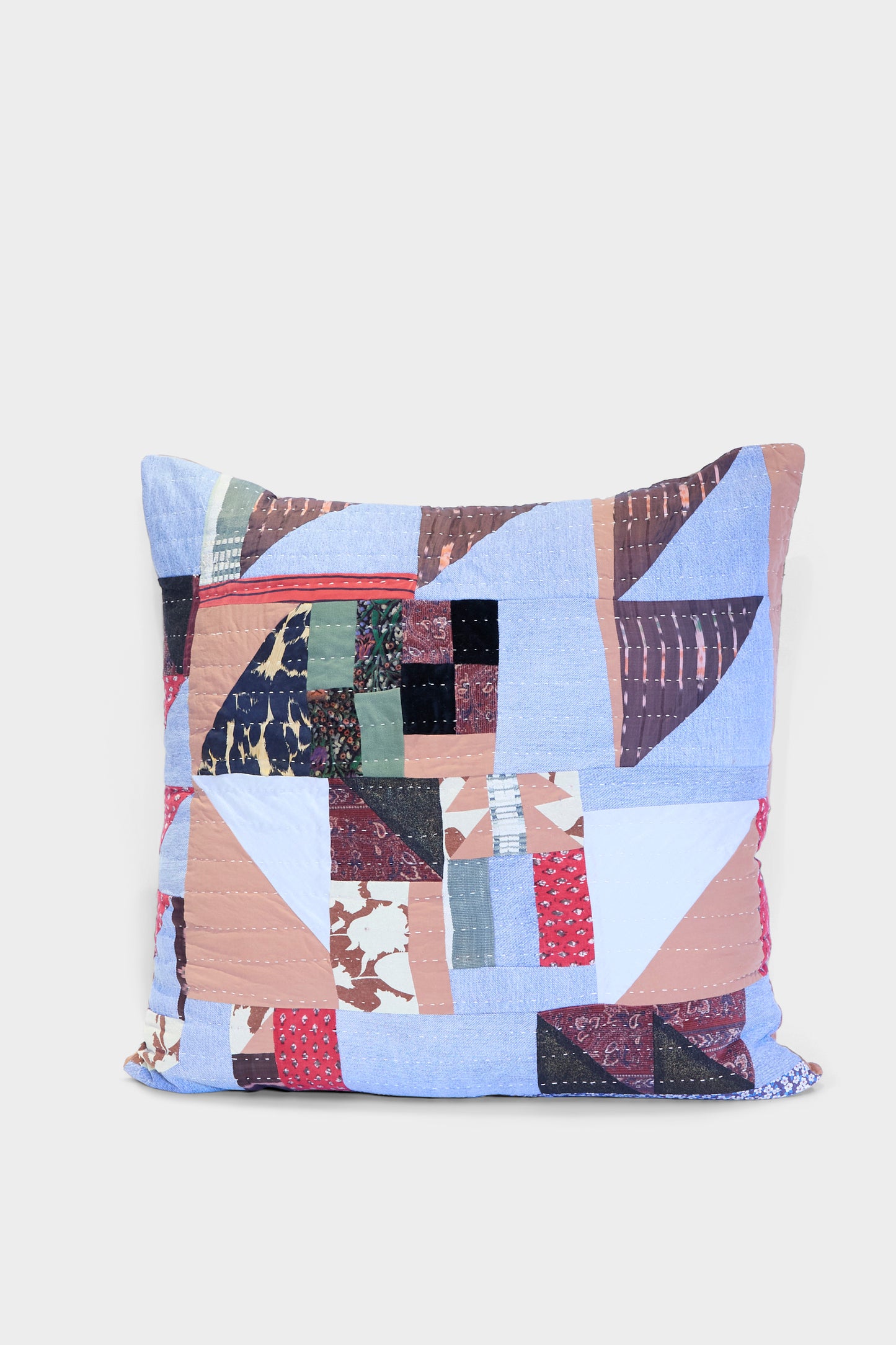 The Counterpane Patchwork Pillow in Denim and Terracotta Multi I features a square design crafted from antique found cloth in blue, brown, red, and green patchwork—made in California. Shown on a plain white background.