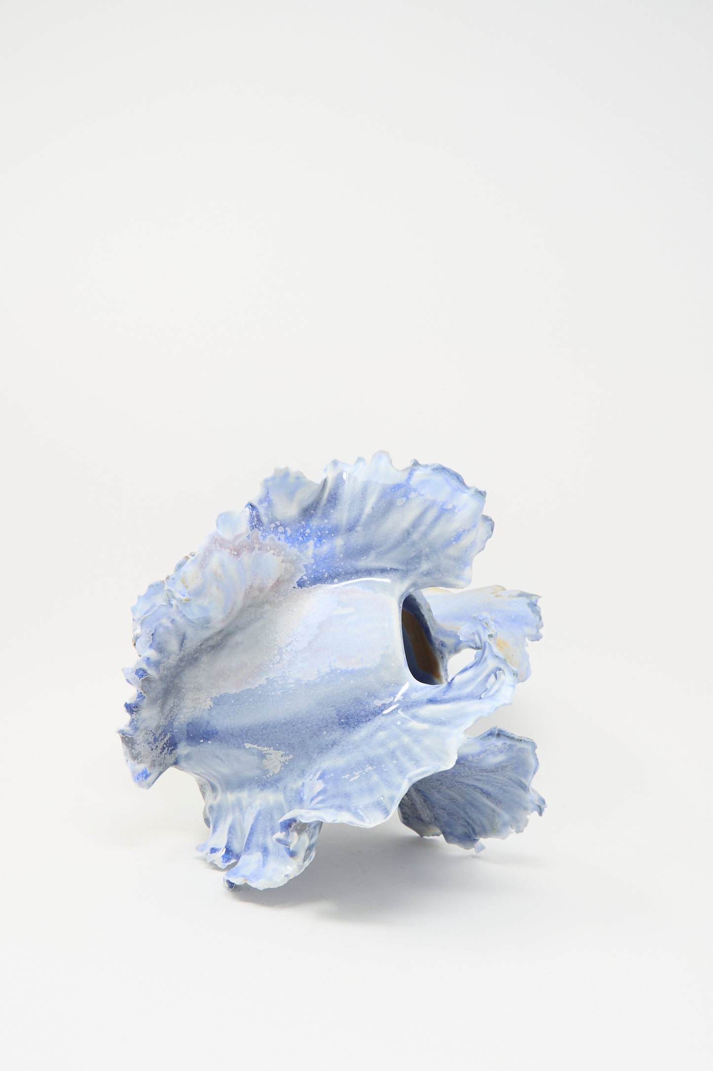 The Ash Bloom N.8 Woodfired in Blue by Dear You is a sculptural porcelain vase with a wavy, ruffled edge and glossy light blue glaze, displayed against a plain white background.