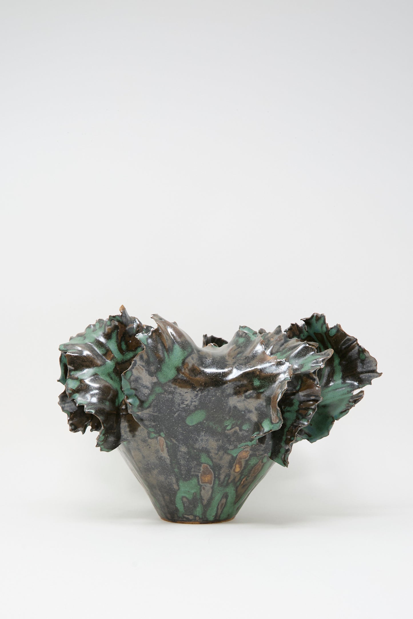 The Wild Petals Iris N.5 in Green by Dear You is a sculpture clay vase with a flared, irregular rim and a textured surface, finished in a green and brown mottled glaze.
